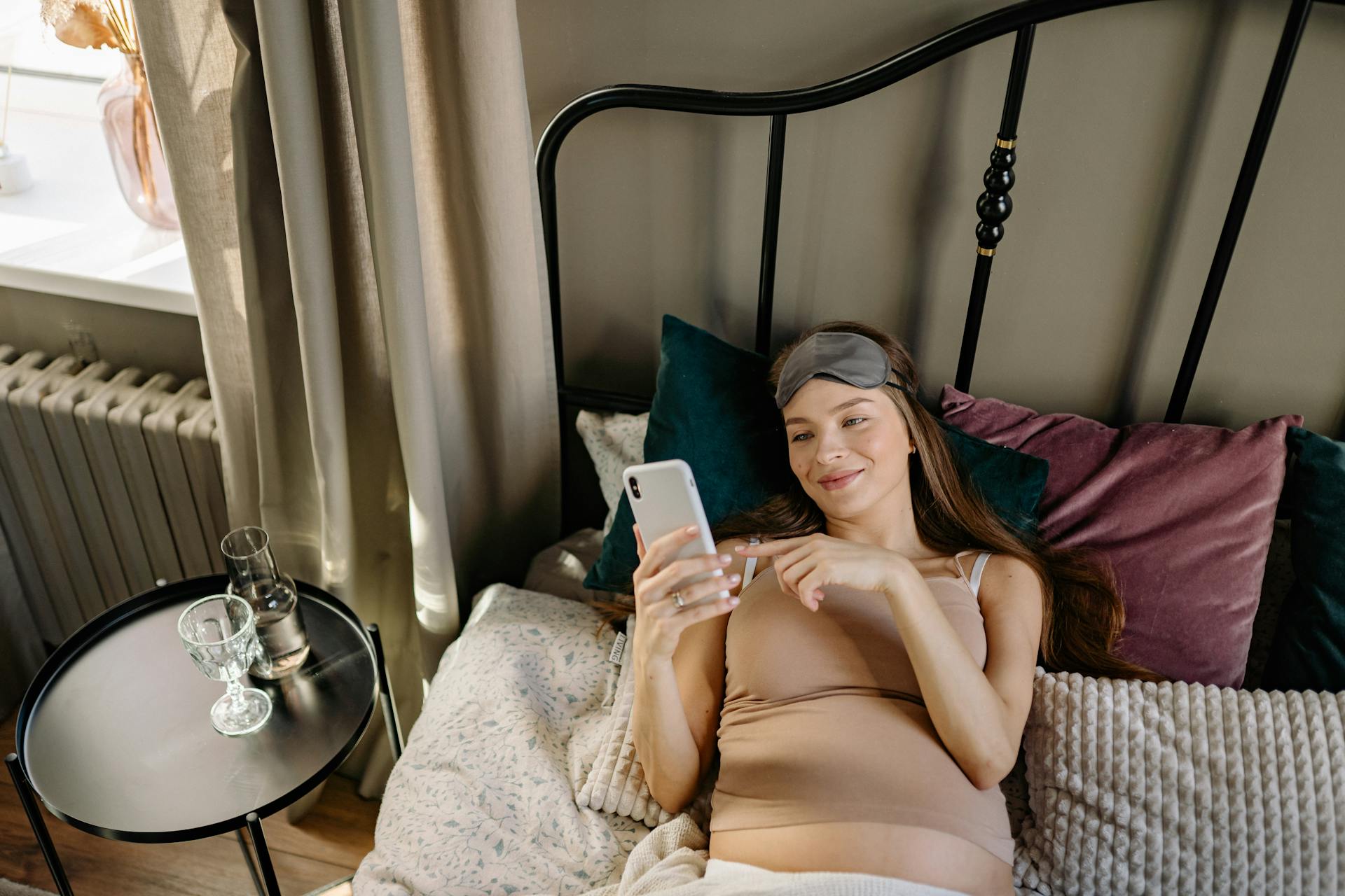 Une femme qui fait défiler son téléphone au lit | Source : Pexels