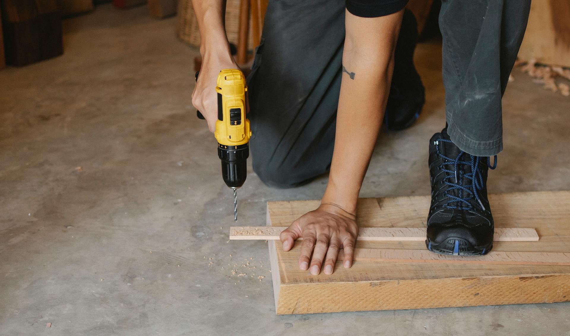 Un homme perce dans du bois | Source : Pexels