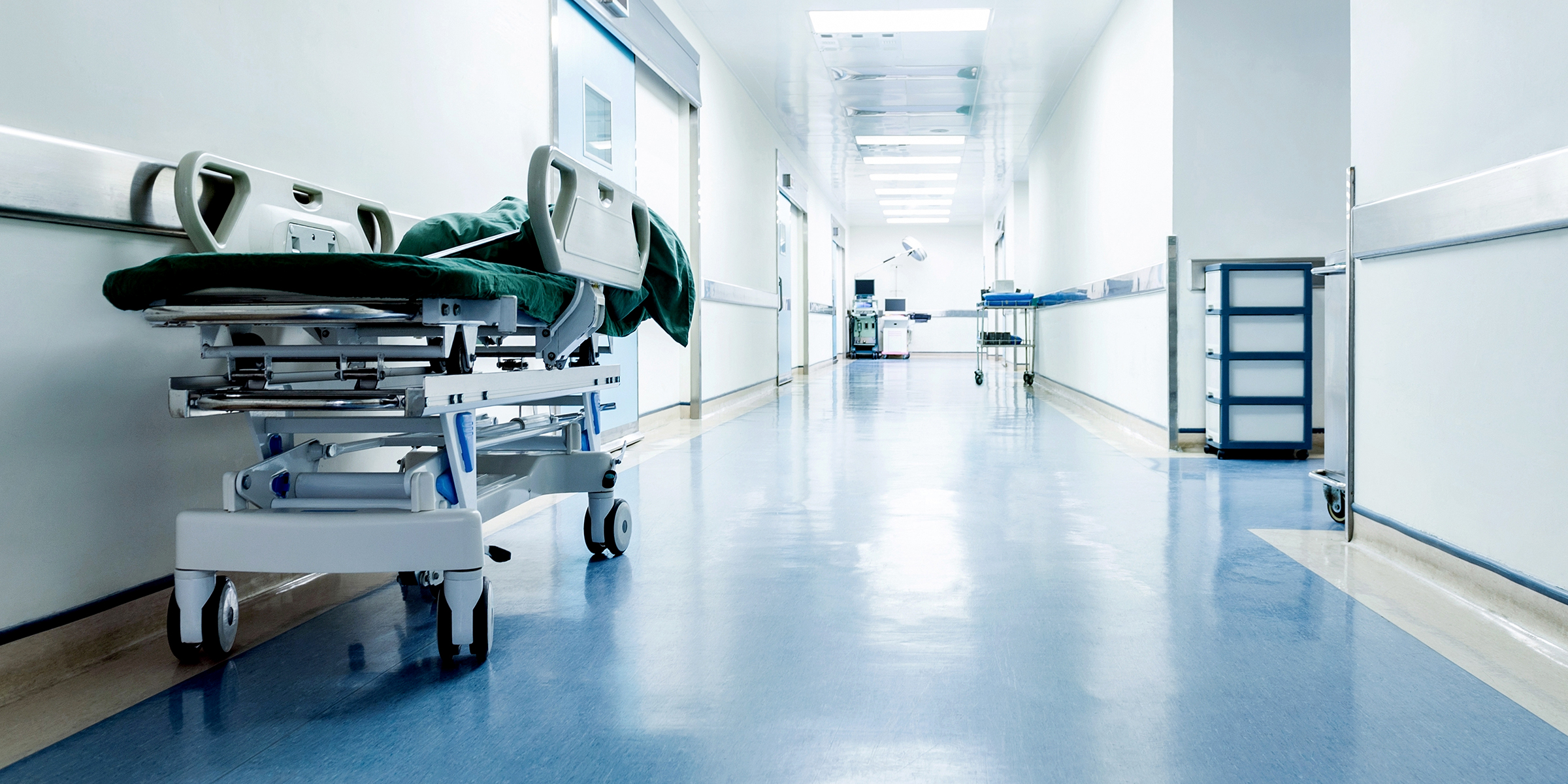 Un couloir d'hôpital vide avec une civière garée le long du mur | Source : Shutterstock