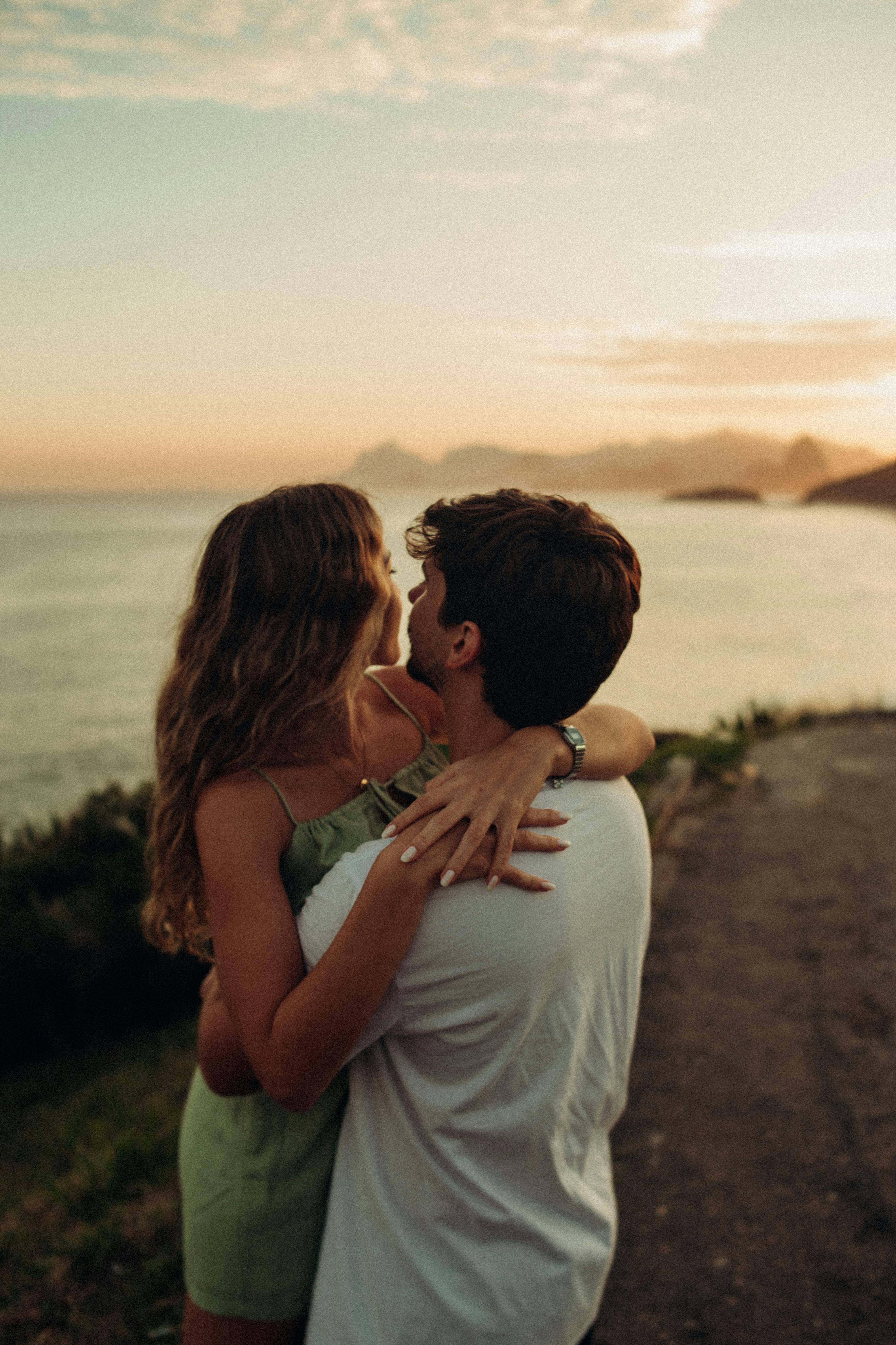 Un couple s'embrassant sur la plage au coucher du soleil | Source : Pexels
