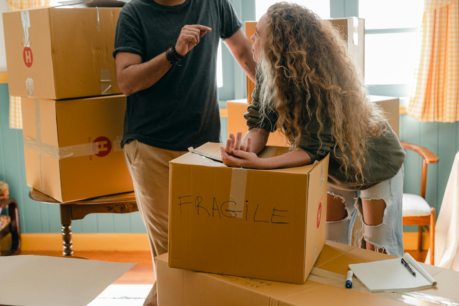 Un couple discute au milieu d'une pile de cartons emballés | Source : Pexels