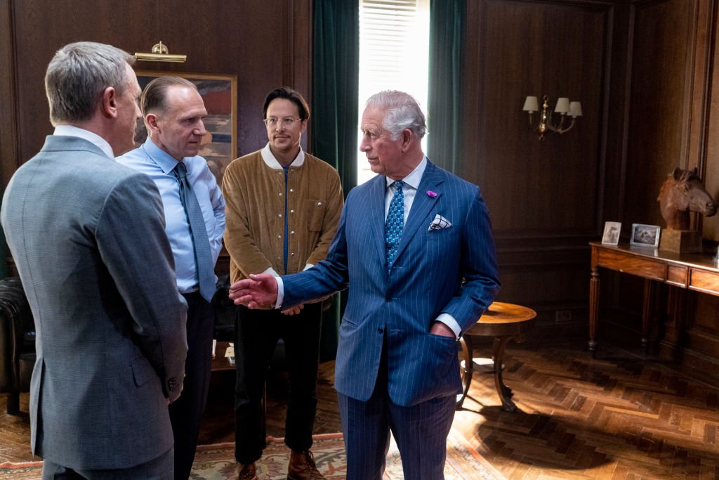Le Prince Charles s'entretient avec les acteurs Ralph Fiennes, Daniel Craig et le réalisateur Cary Joji Fukunaga lors d'une tournée du nouveau film "James Bond" en juin 2019 | Photo : Getty Images