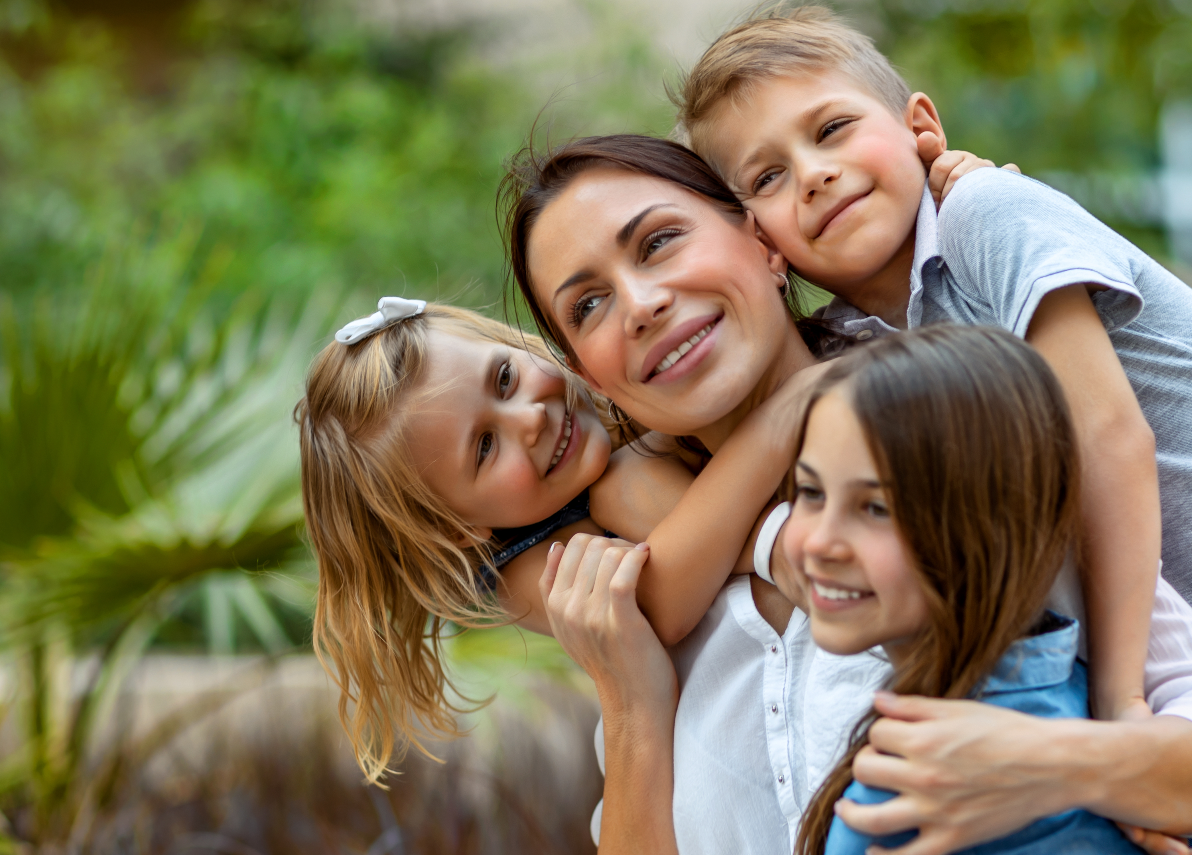 Une mère serrant ses trois enfants dans ses bras | Source : Shutterstock