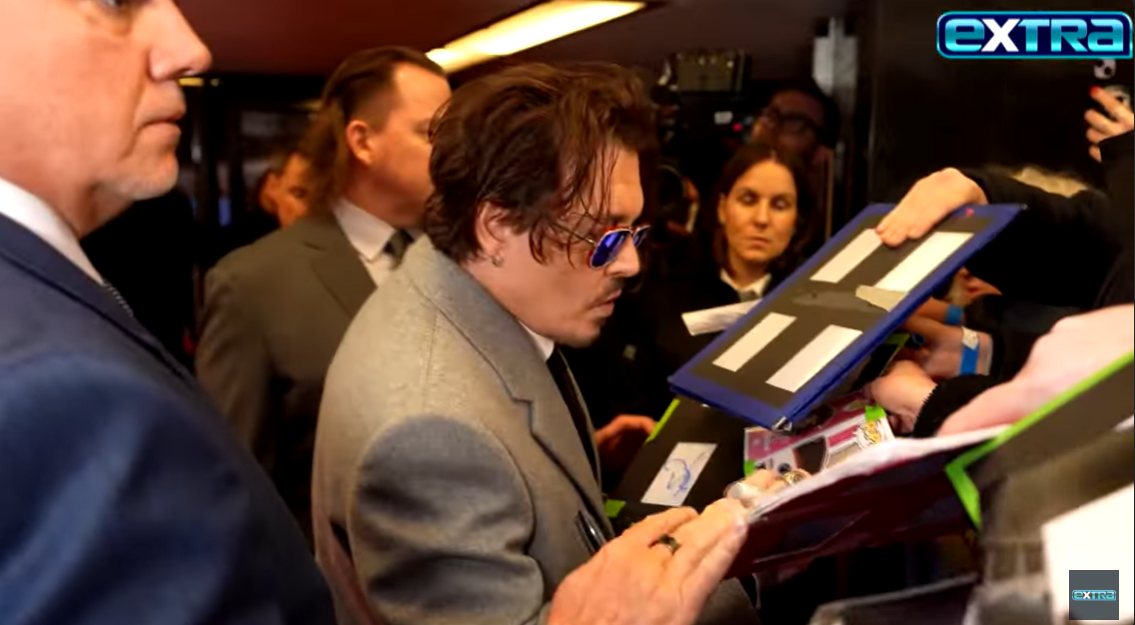 Johnny Depp signe des autographes lors de la première de "Jean Du Barry" à Londres, en Angleterre. | Source : YouTube/extratv
