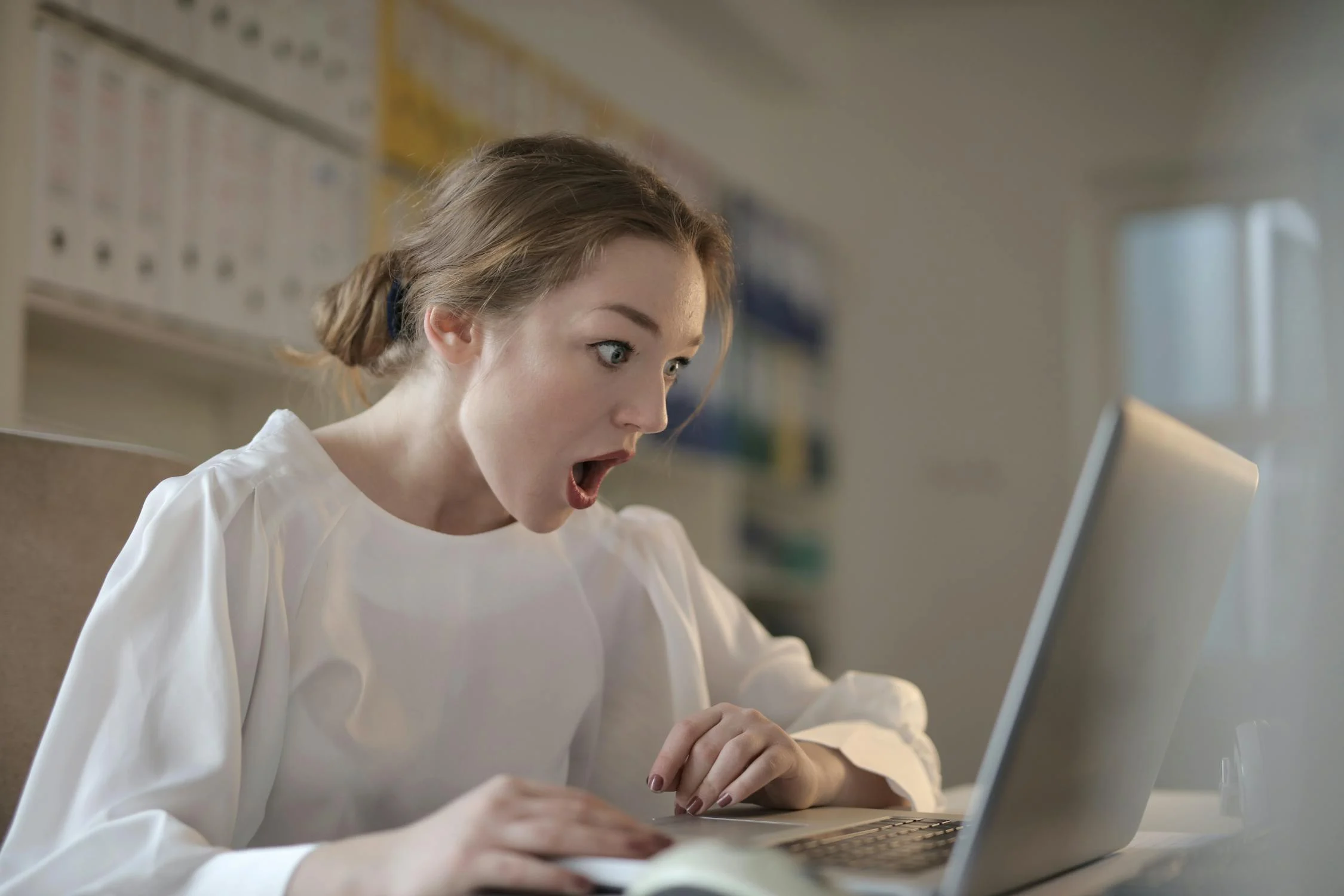 Une femme choquée qui regarde son ordinateur portable | Source : Pexels