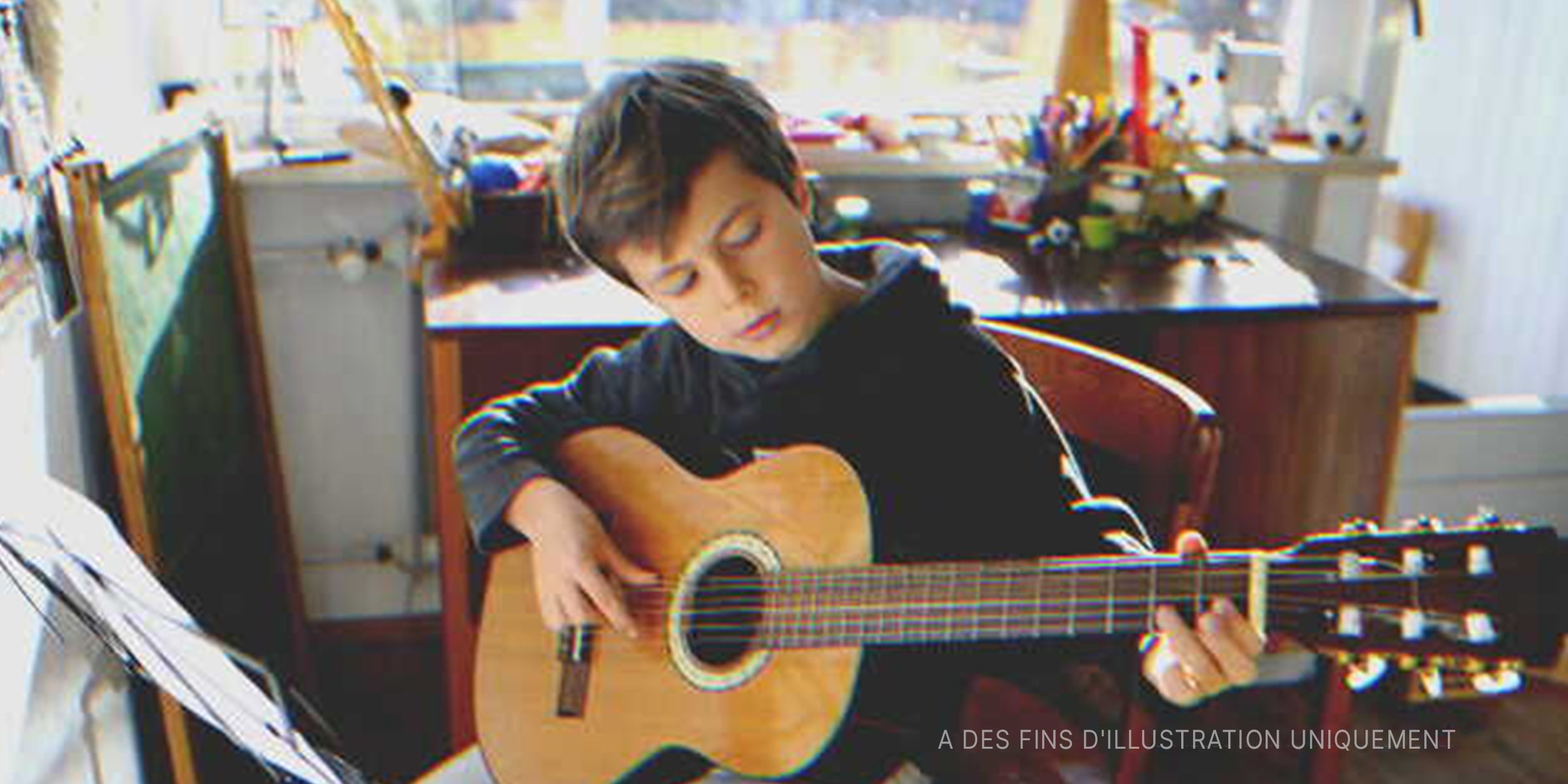 Un jeune garçon jouant de la guitare | Source : Shutterstock 