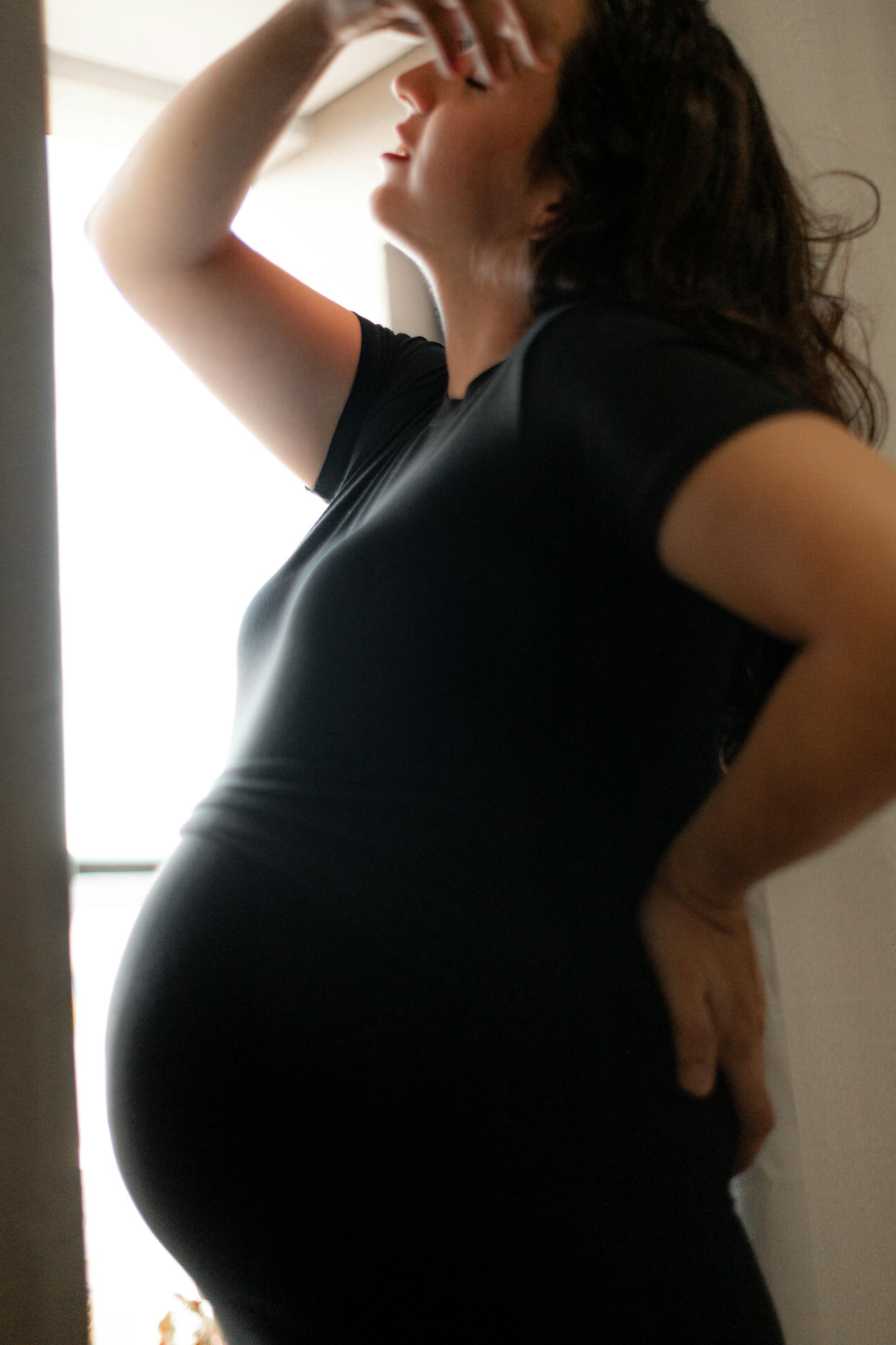 Une femme enceinte bouleversée debout près de la fenêtre | Source : Pexels