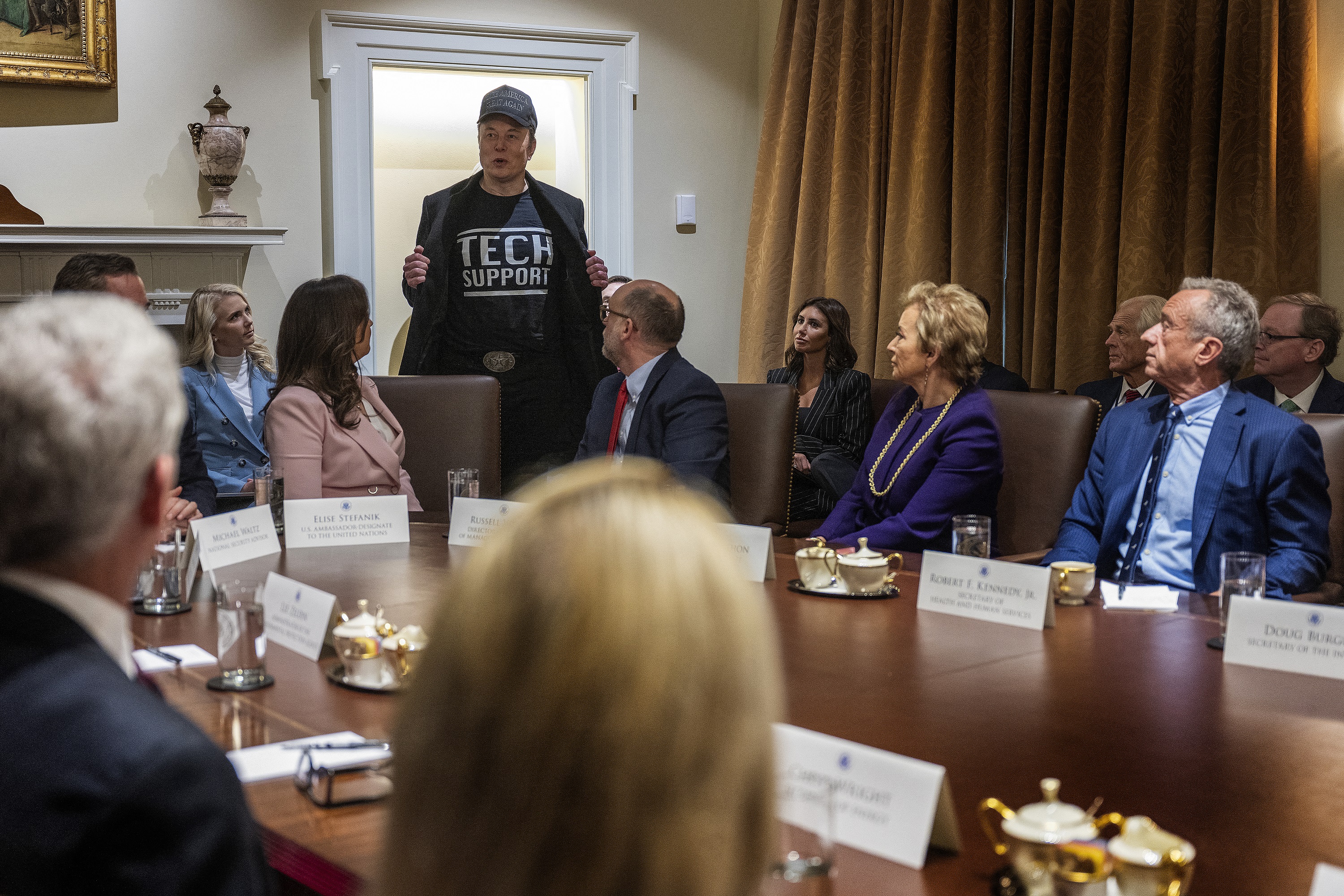 Elon Musk porte un T-shirt "Tech Support" lors d'une réunion du cabinet à la Maison Blanche à Washington, DC, le 26 février 2025 | Source : Getty Images