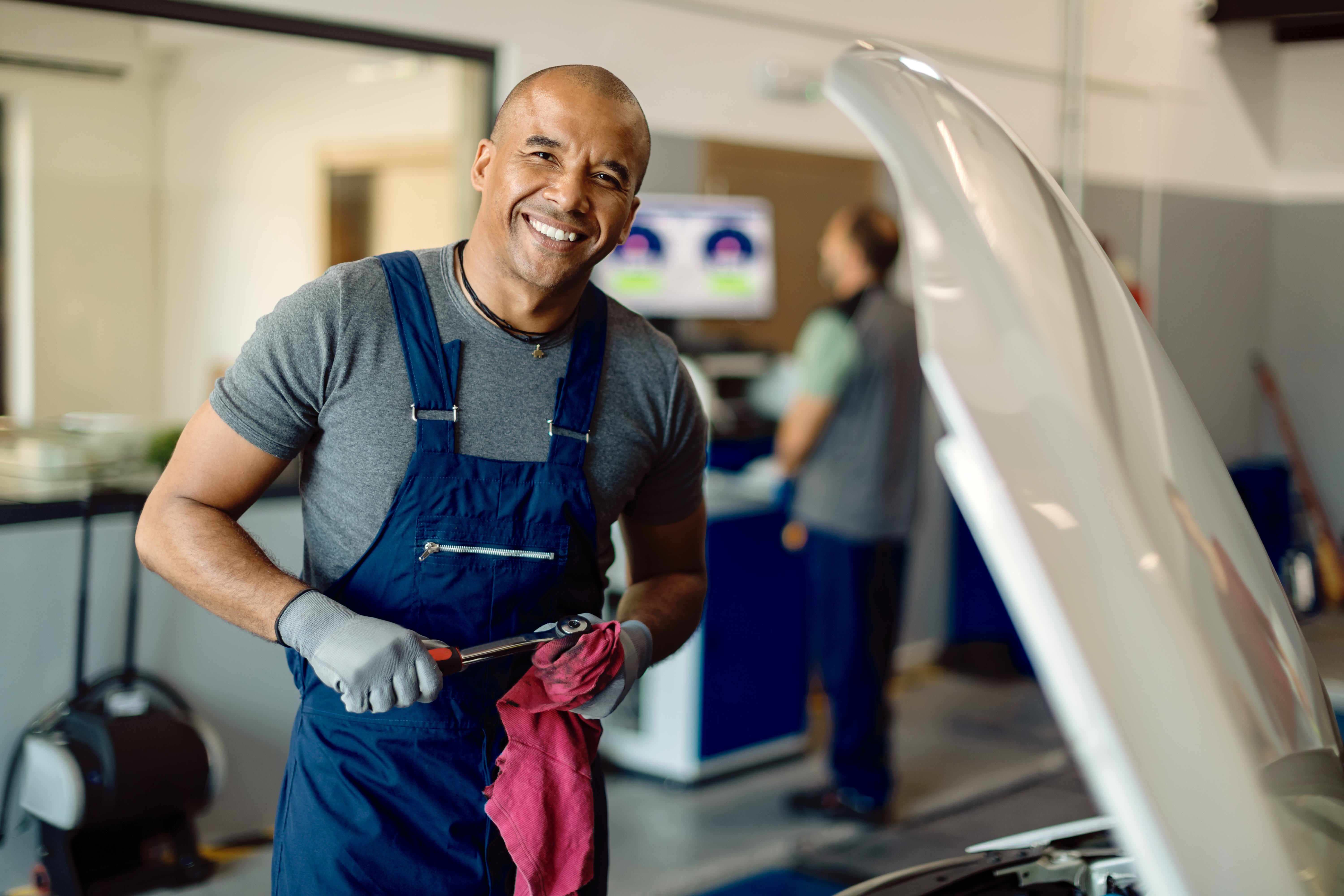 Un mécanicien souriant au travail | Source : FreePik