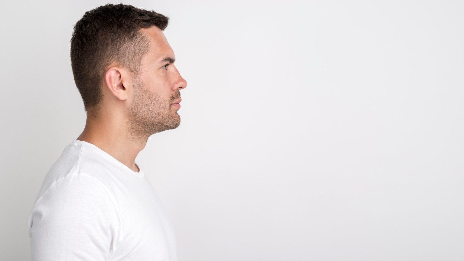 Vue de côté d'un homme qui regarde devant lui | Source : Freepik