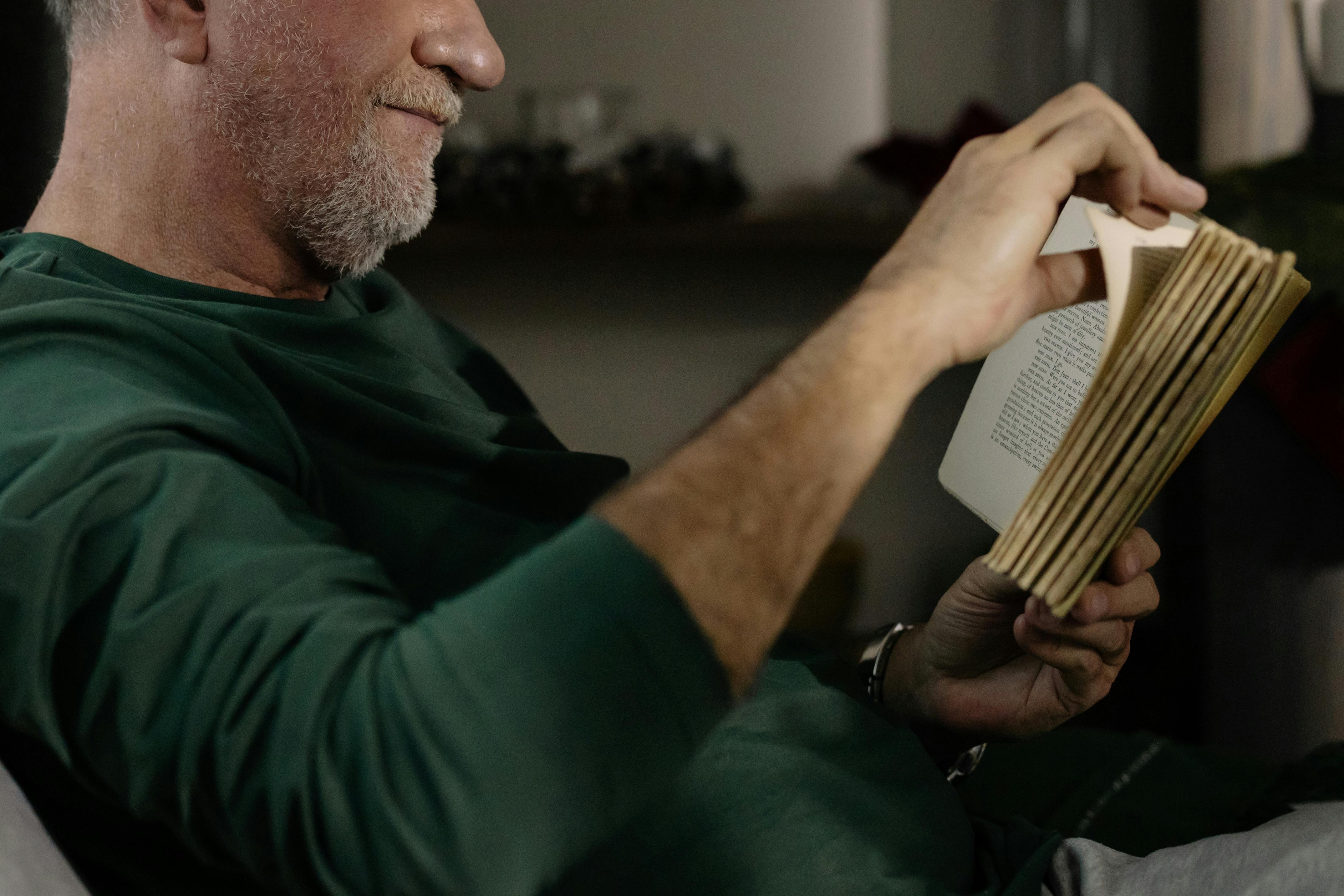 Un vieil homme feuilletant un livre | Source : Pexels