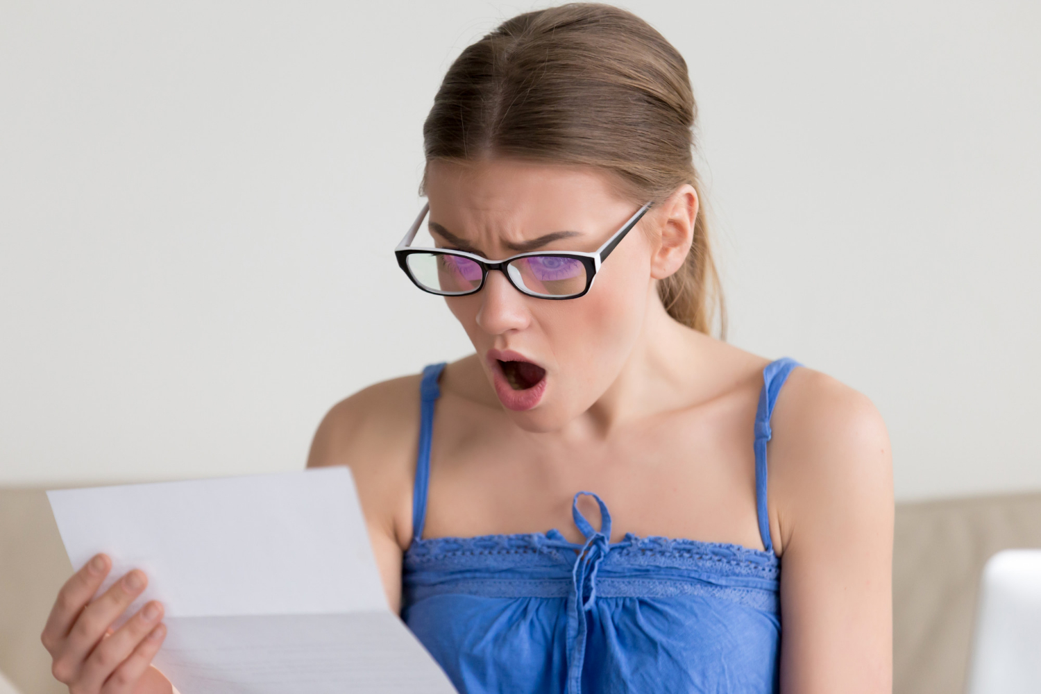 Une femme choquée lisant une lettre | Source : Freepik