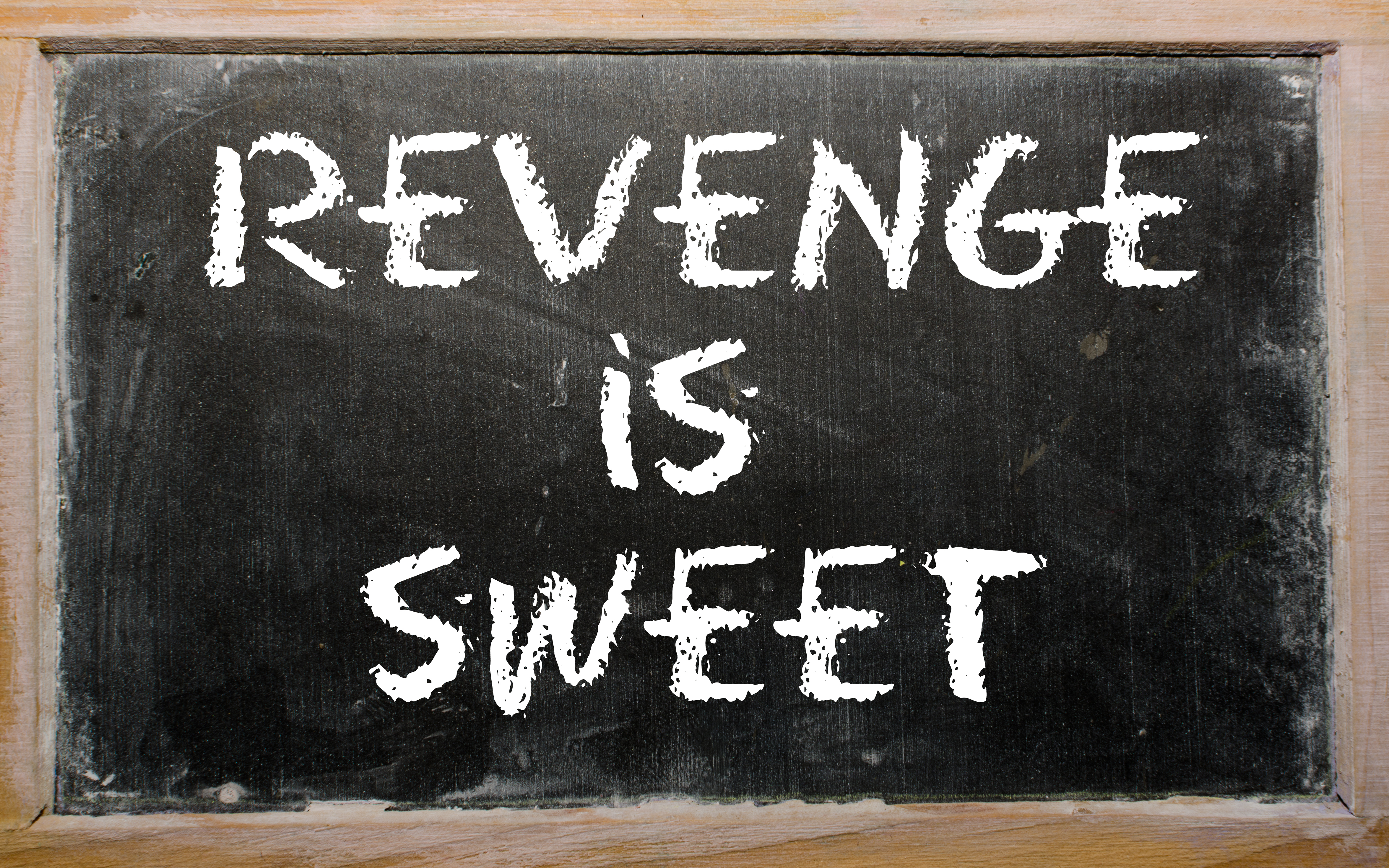 Les mots "La vengeance est douce" écrits sur un tableau noir | Source : Shutterstock