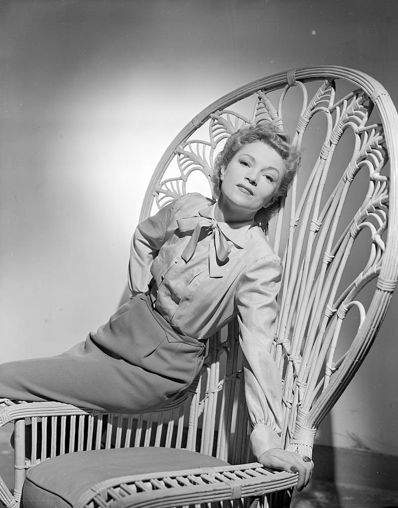 L'actrice française Annabella (alias Suzanne Georgette Charpentier) appuyée contre une chaise en rotin à dossier haut ; Tourné en 1944. | Photo : Getty Images