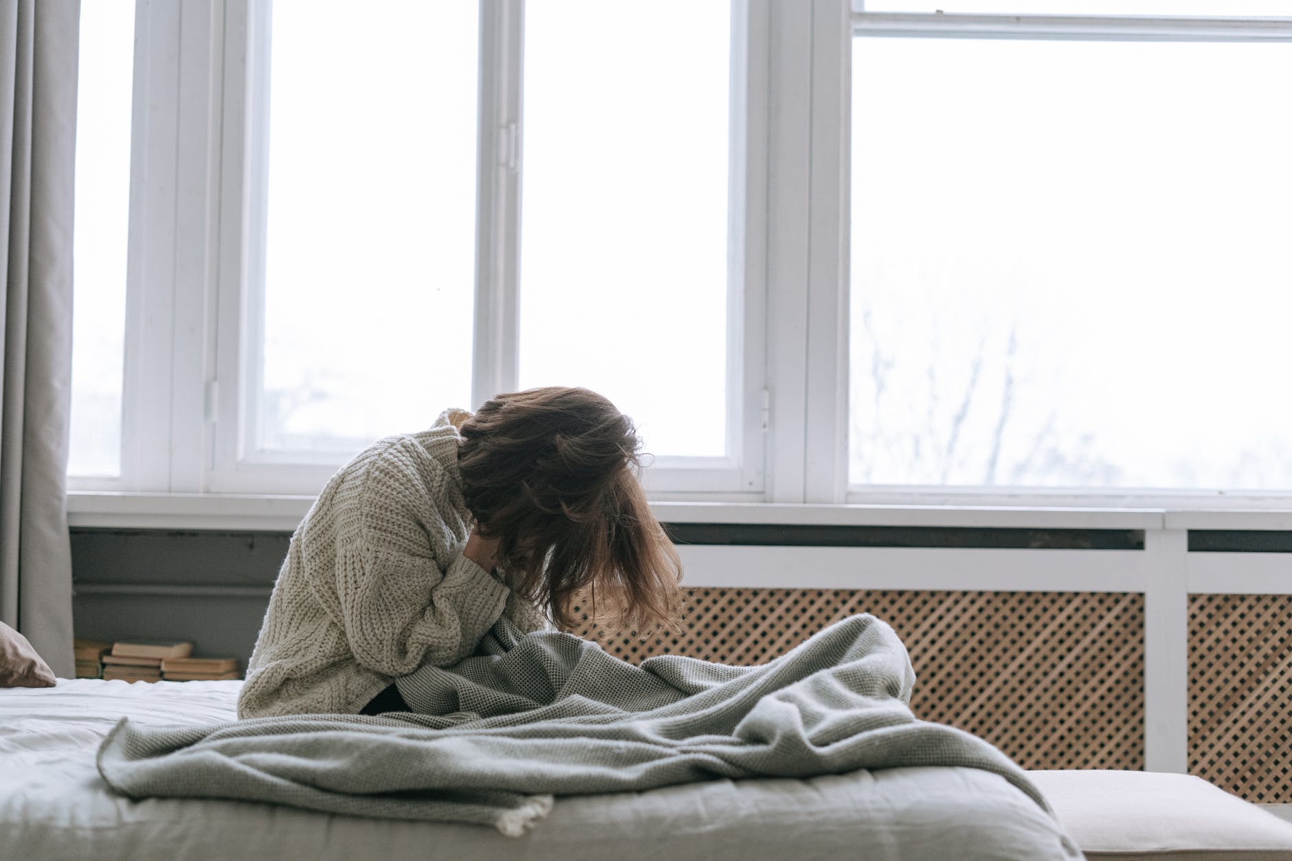 Une femme entrain de pleurer au lit. | Photo : Pexels