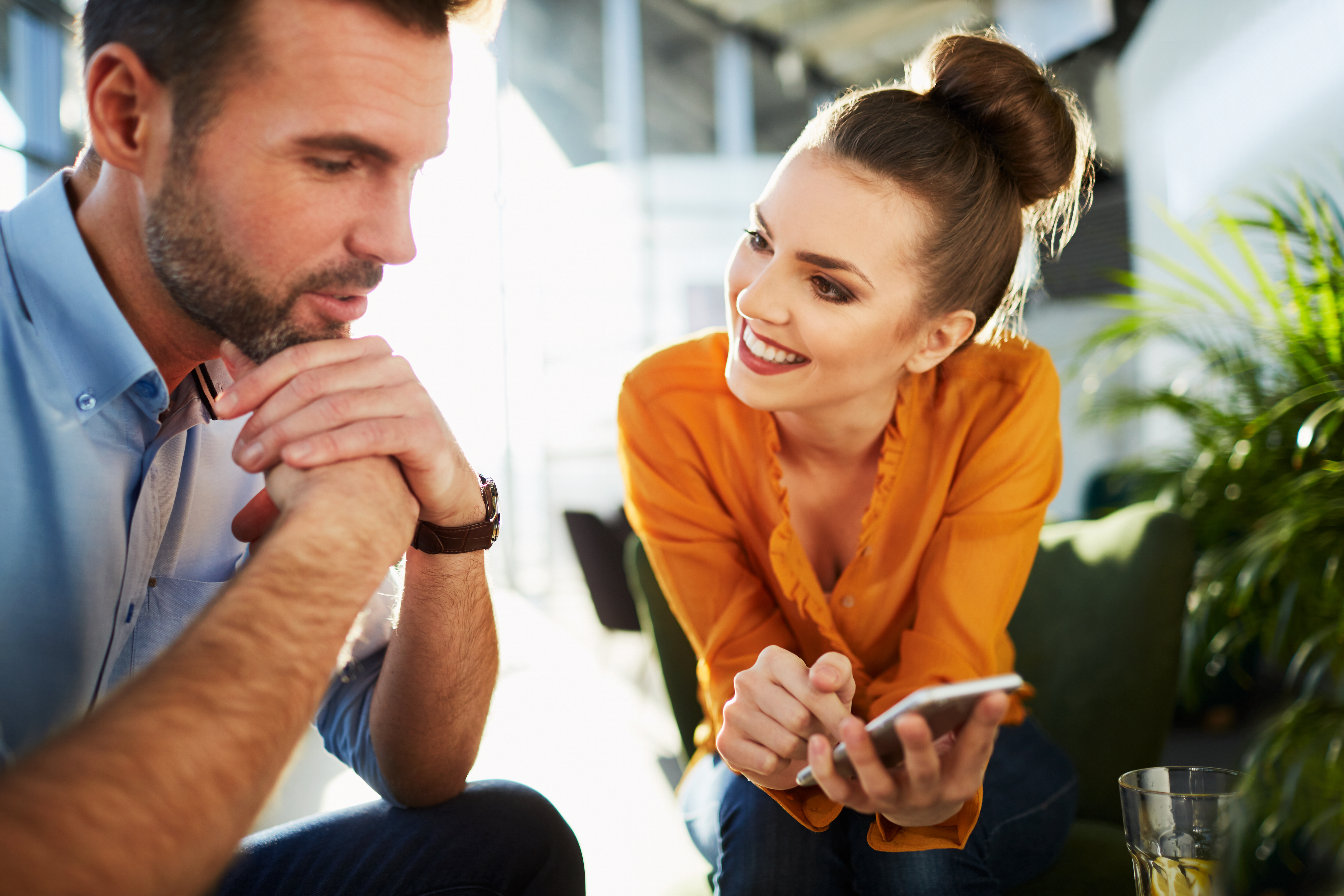 Un homme en train de parler avec une femme qui montre quelque chose sur son téléphone | Source : Shutterstock