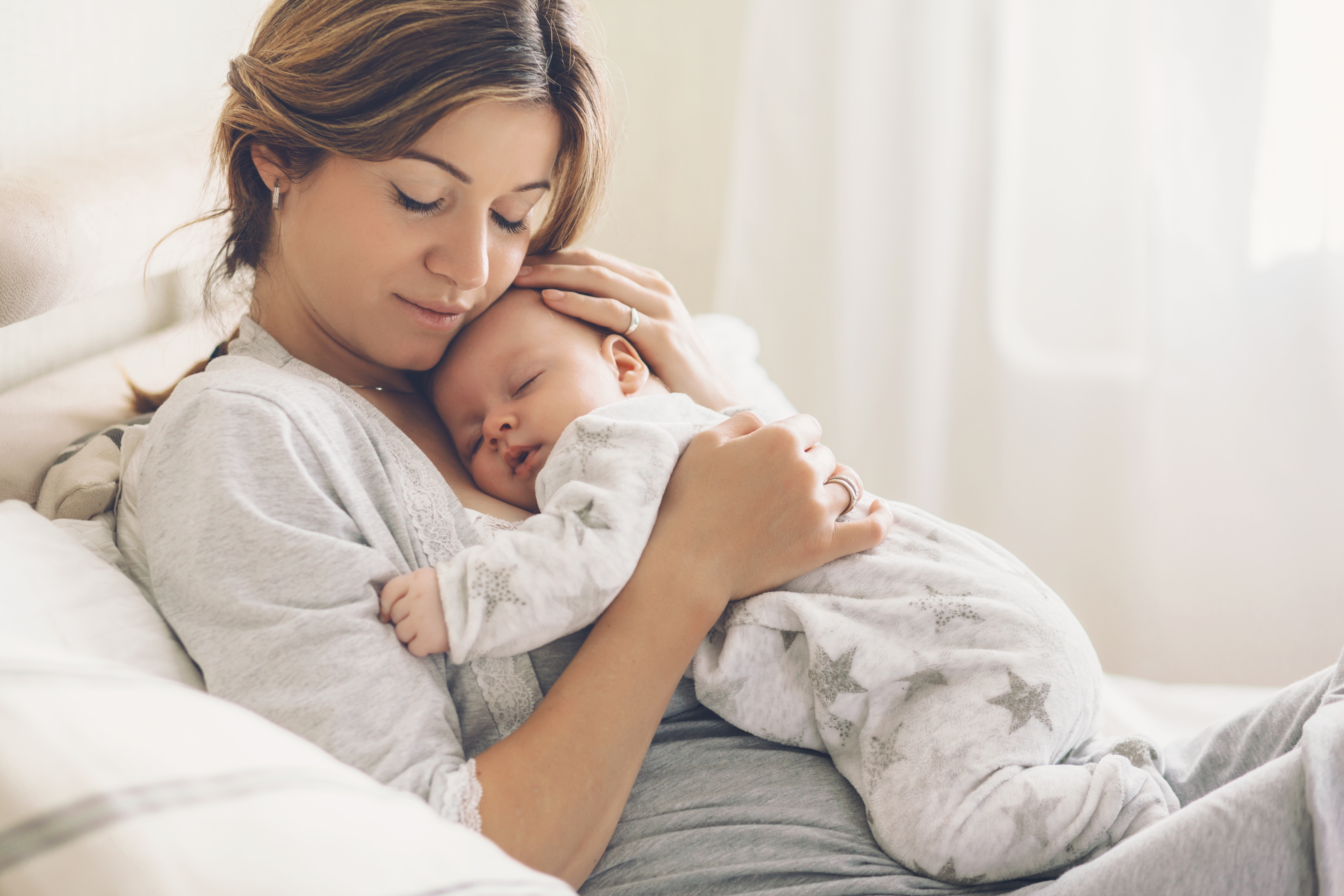 Une femme avec un bébé dormant sur sa poitrine | Source : Shutterstock