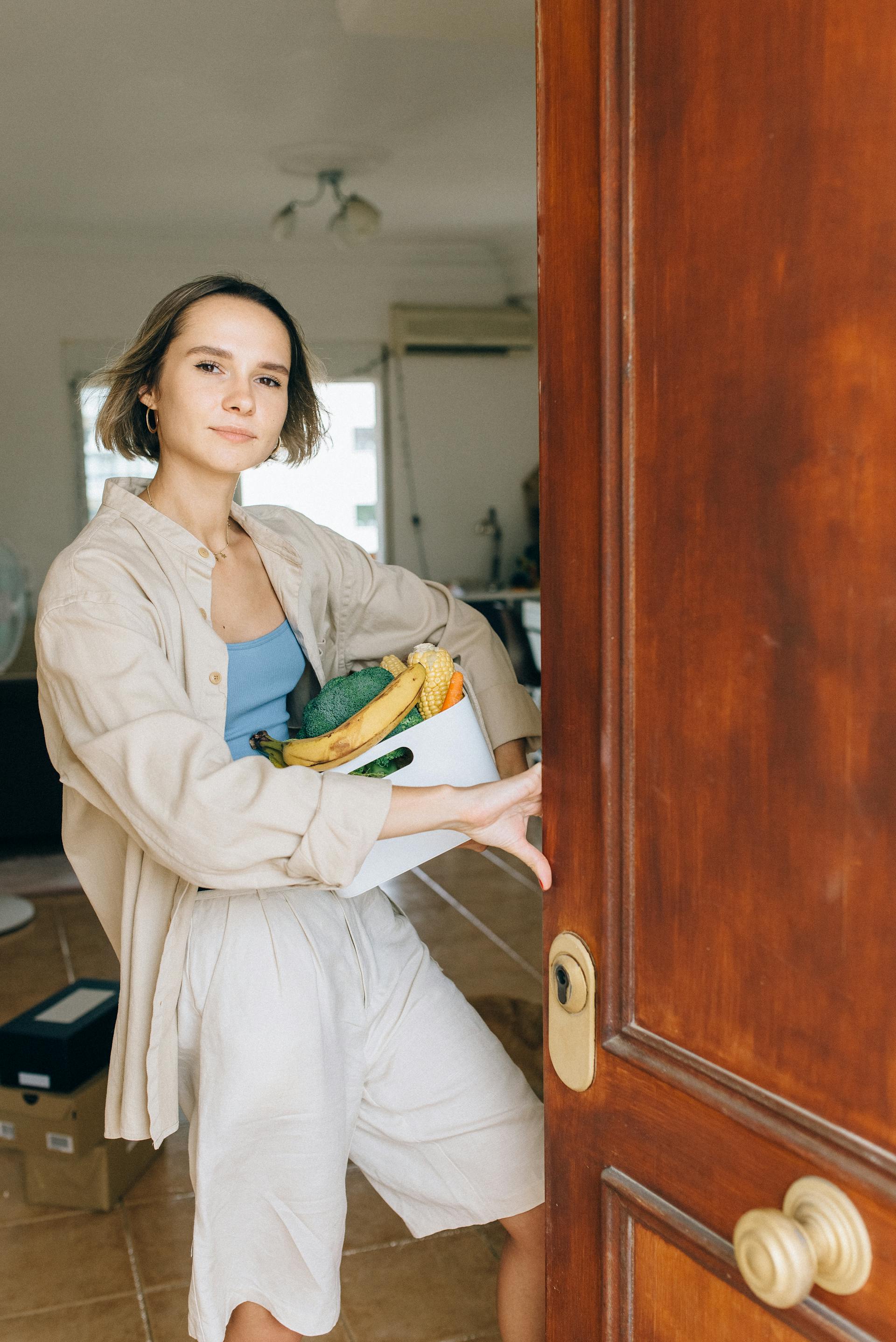 Une femme debout dans l'embrasure de la porte ouverte de son appartement | Source : Pexels