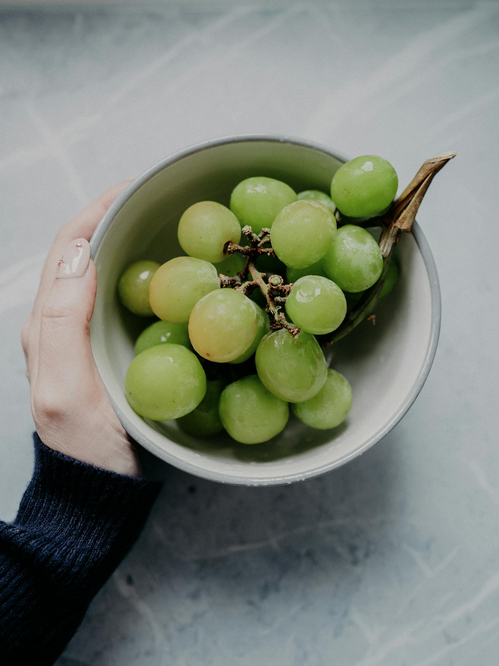 Une personne tenant un bol de raisins | Source : Pexels
