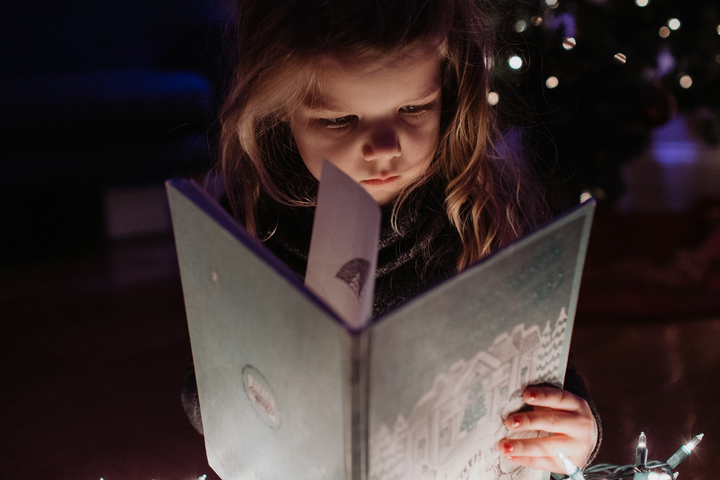 Une petite fille tenant un livre | Source : Unsplash