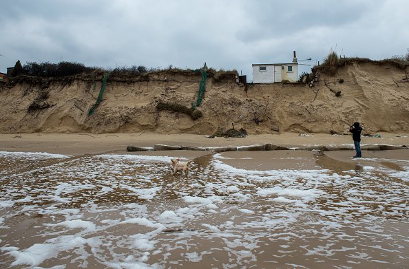 Un homme promène son chien le long de la plage d'Hemsby. |Photo : Getty Images