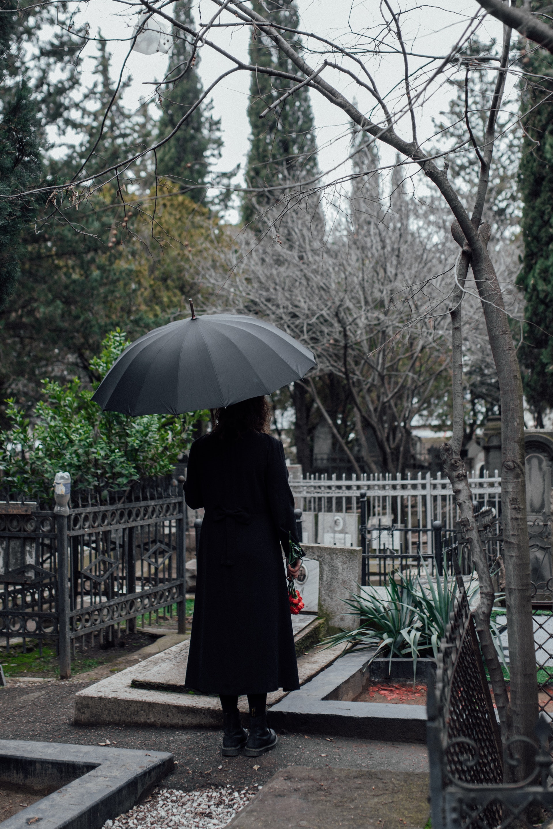 Une femme tenant un parapluie au cimetière | Source : Pexels