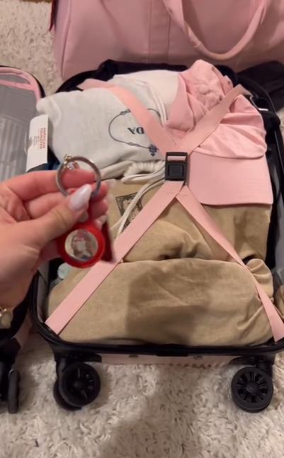 Katarina Mogus tenant un Apple AirTag près de son sac à bagages, comme on peut le voir dans une vidéo 27 juin 2022 | Source : TikTok/@katamogz