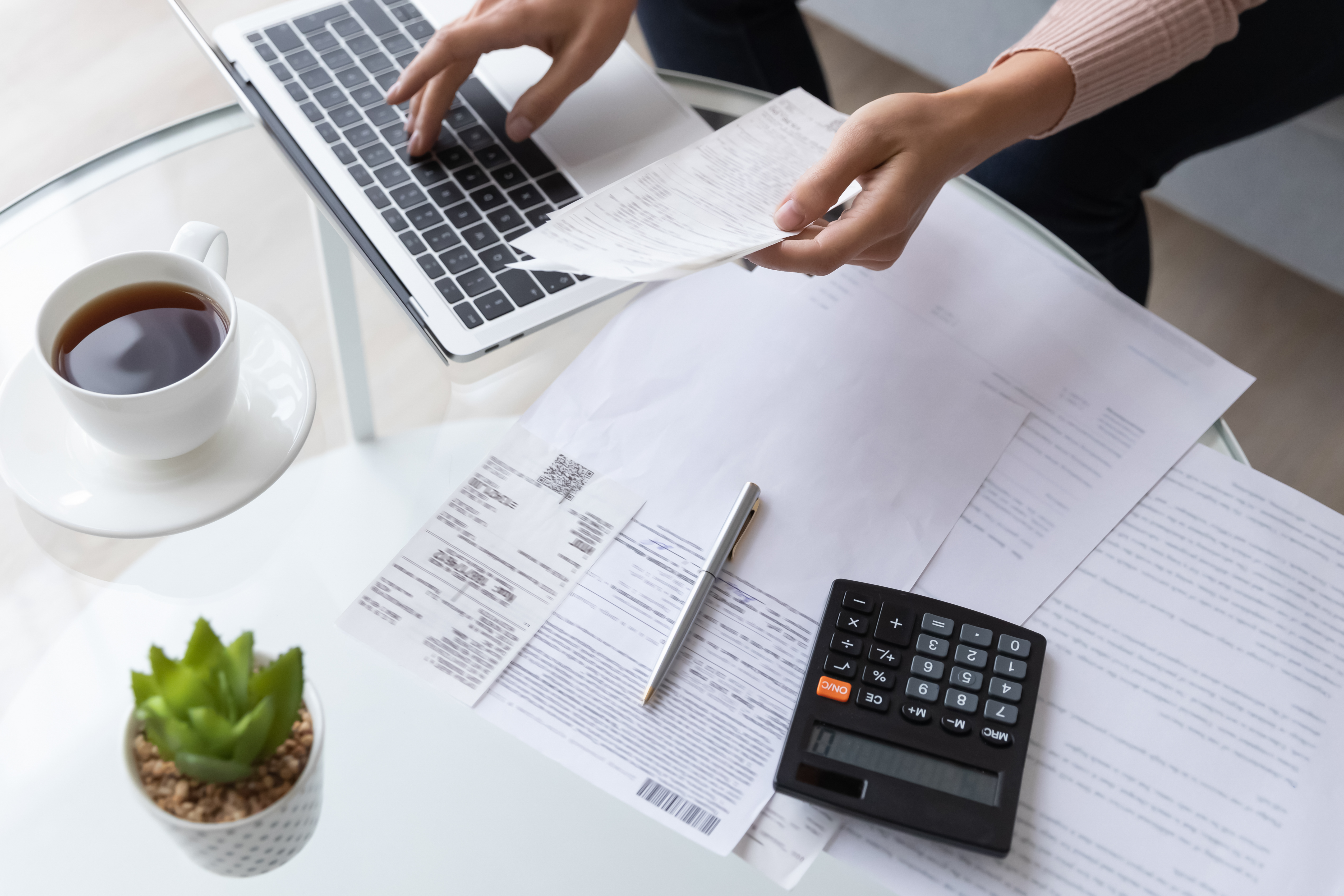 Photo en gros plan d'une personne qui consulte des documents financiers | Source : Shutterstock