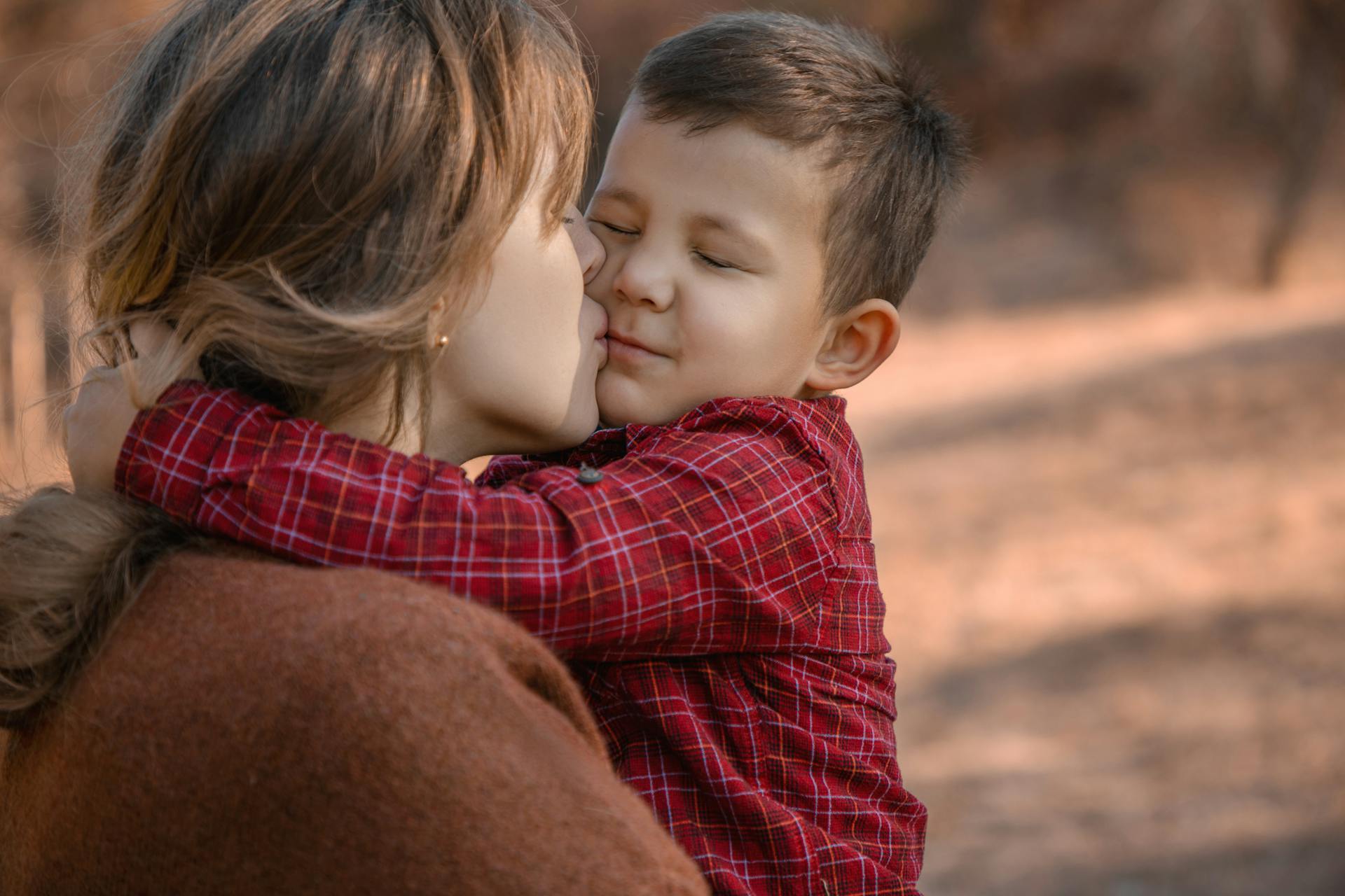 Une mère embrassant son petit garçon dans un parc | Source : Pexels