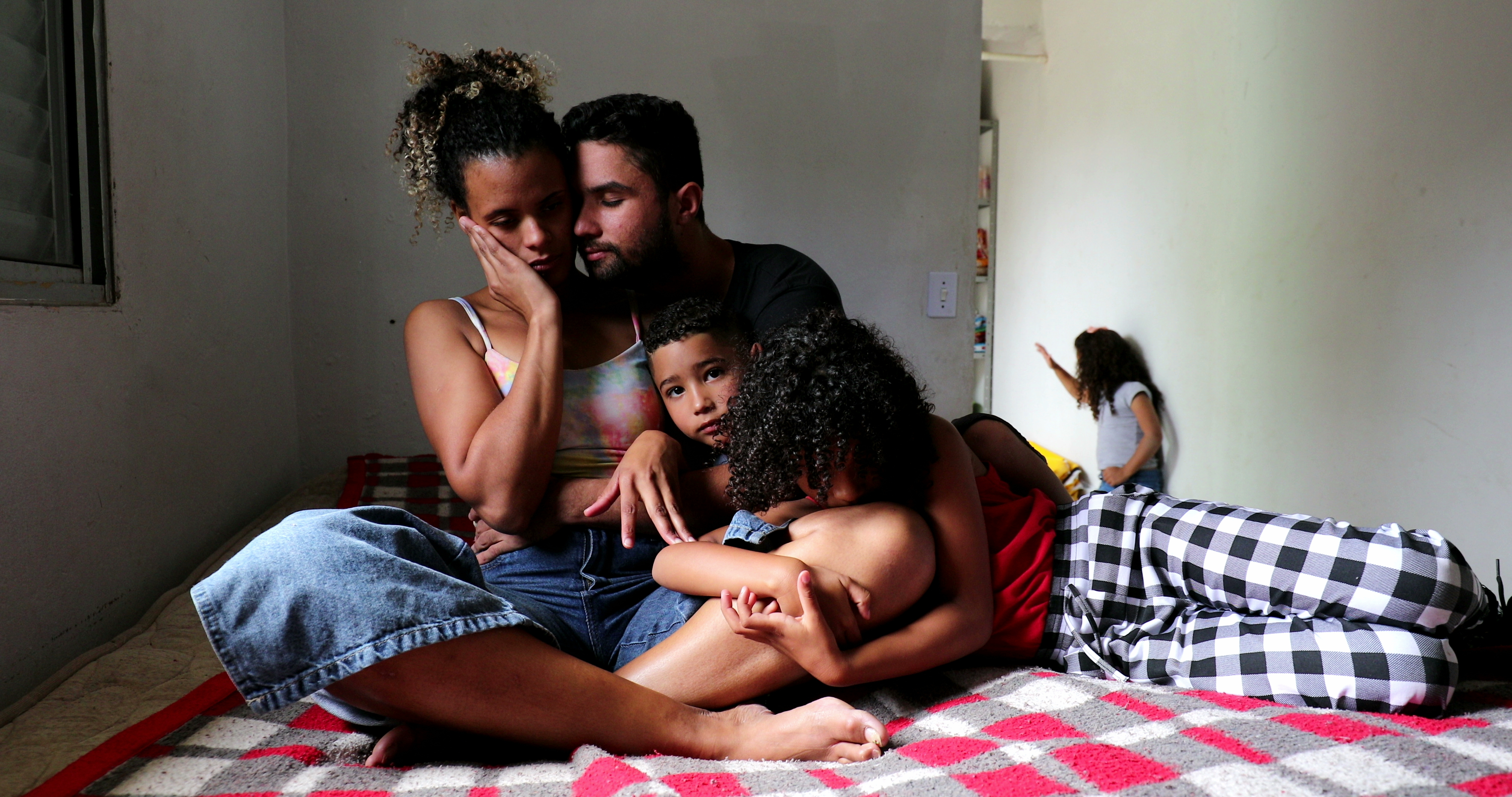 Un homme, une femme et deux enfants en train de se blottir | Source : Shutterstock