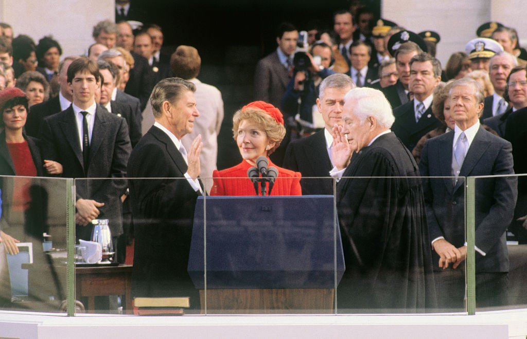 Le président élu Ronald Reagan prête le serment d'office lors des cérémonies d'investiture à Washington, DC. Sa femme, Nancy, tient la Bible et le juge en chef Warren Burger fait prêter le serment. | Source : Getty Images