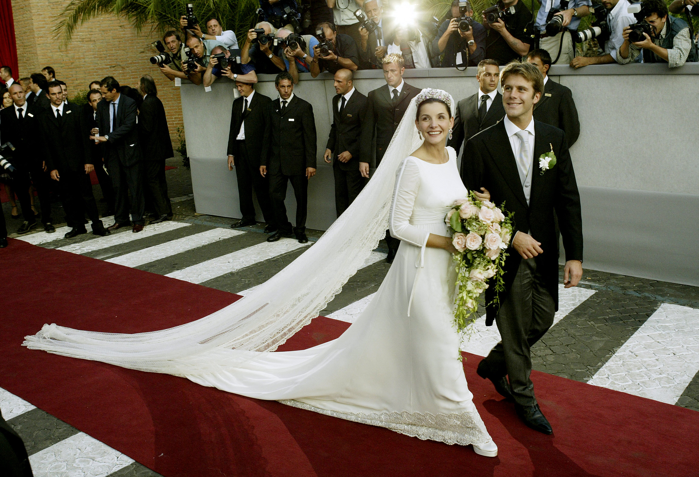 Emmanuel Philibert de Savoie (à droite) et l'actrice française Clotilde Courau quittent l'église Santa Maria degli Angeli après leur mariage à Rome, le 25 septembre 2003 I Source : Getty Images