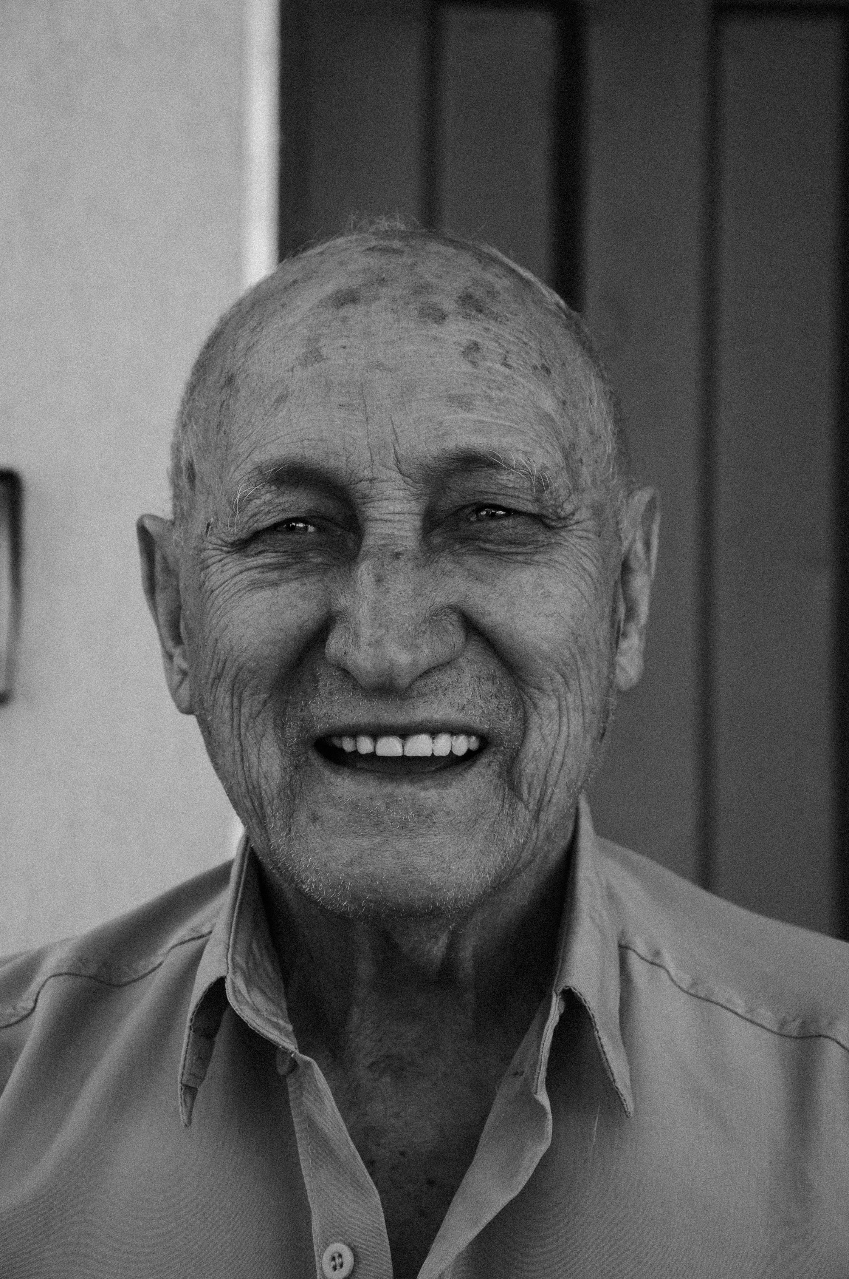 Une photo en noir et blanc d'un homme âgé souriant | Source : Pexels