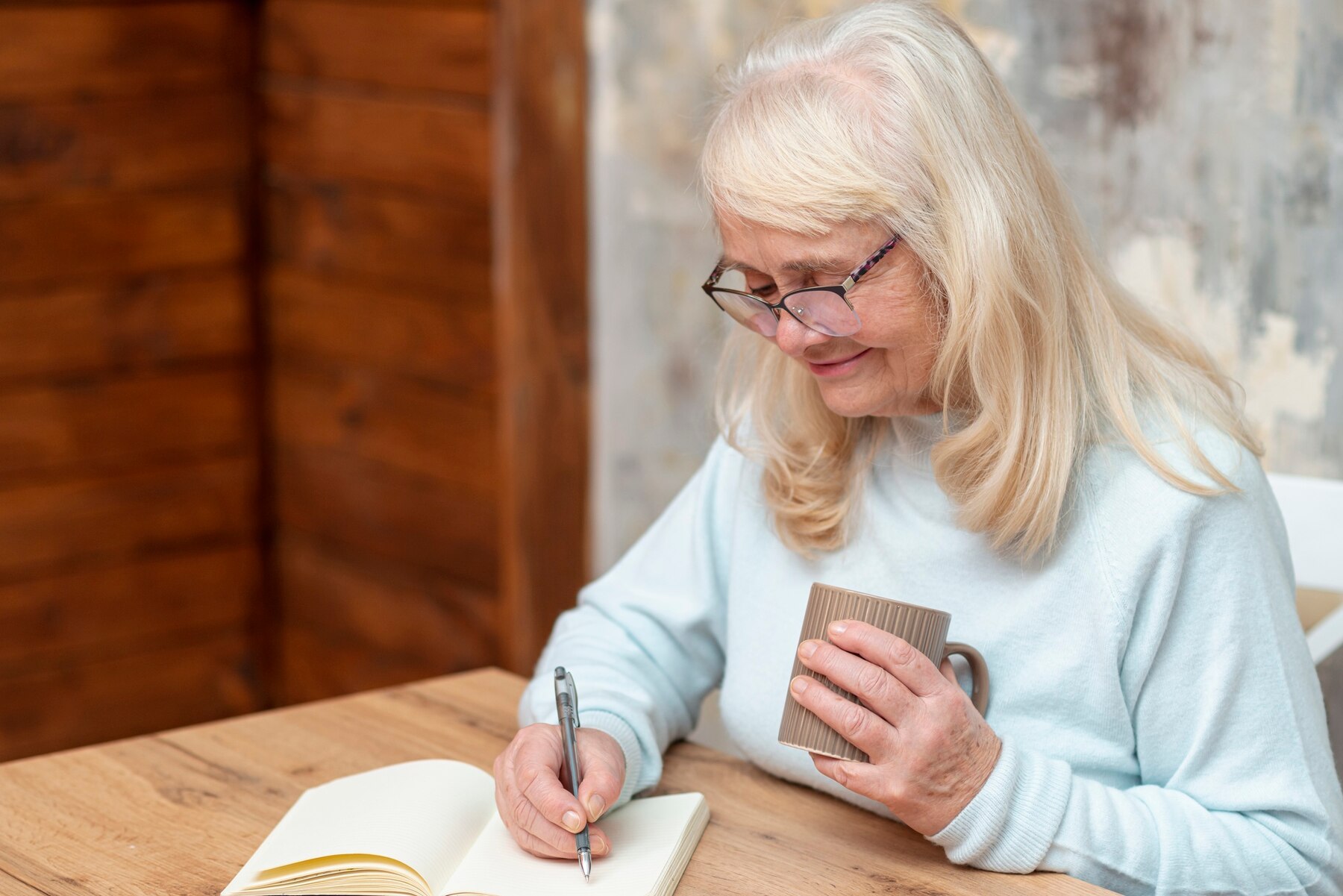 Eine Frau, die in ihr Notizbuch schreibt | Quelle: Freepik