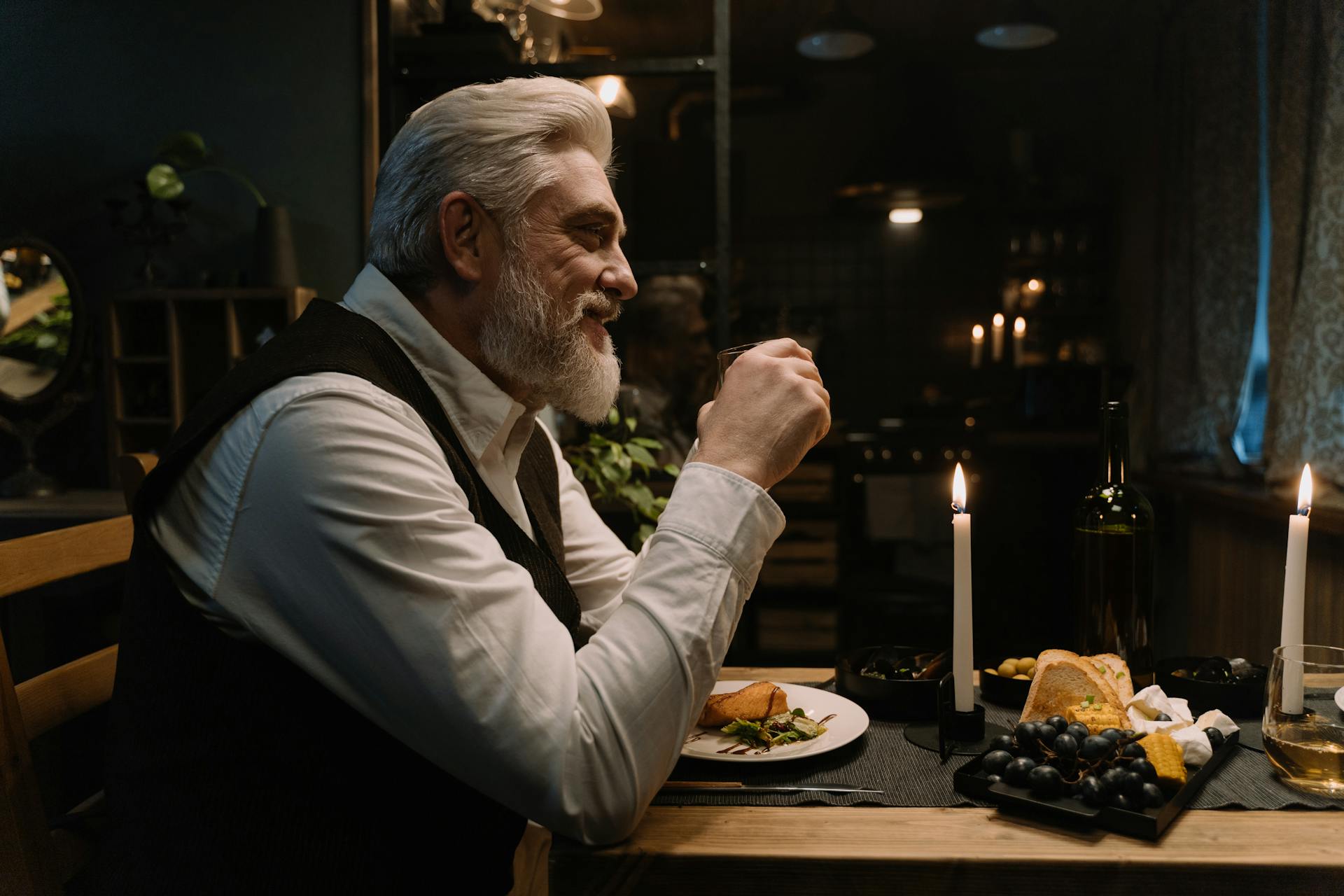 Un homme âgé assis dans une salle à manger huppée et souriant | Source : Pexels