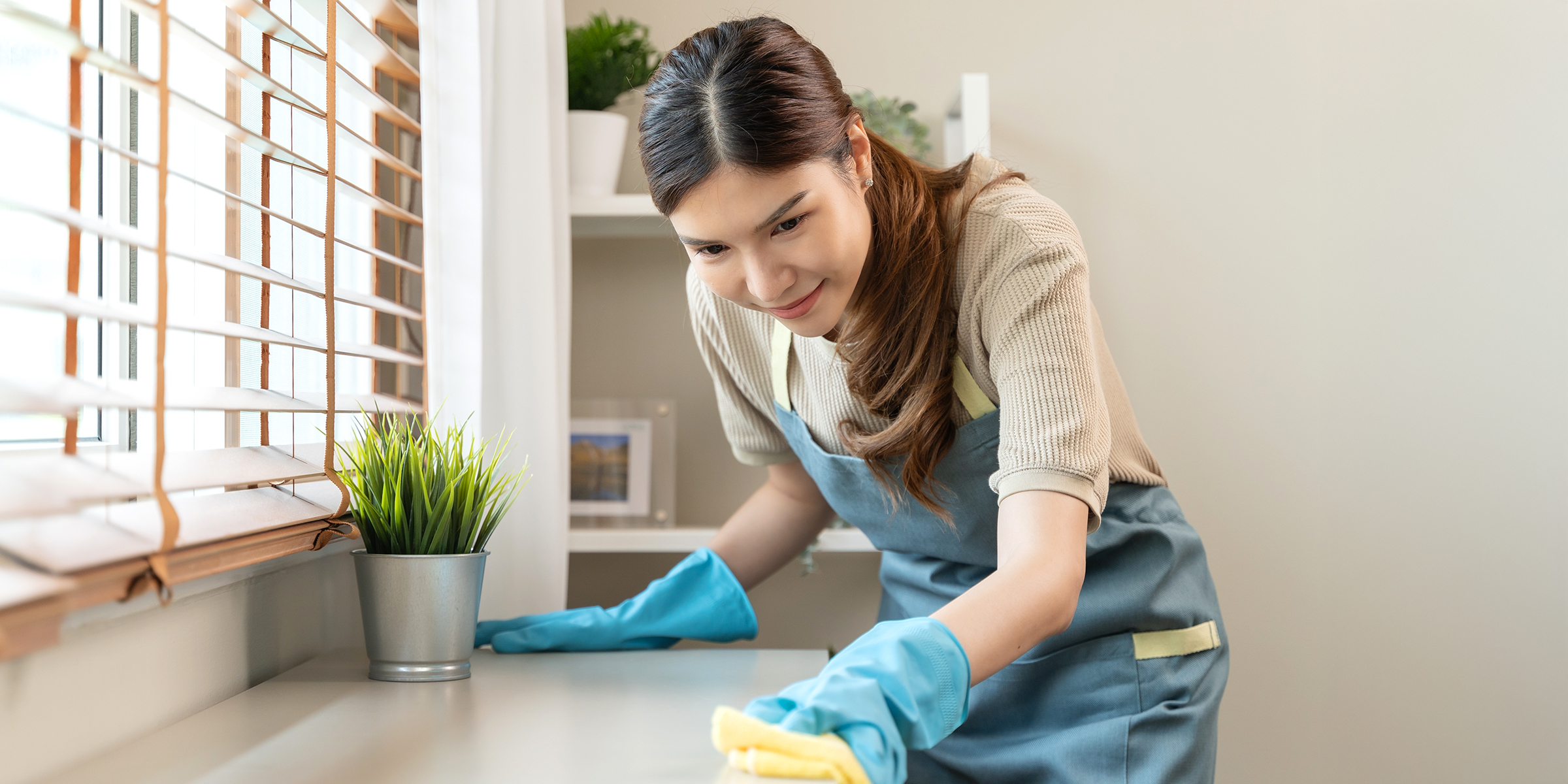 Une femme essuie un comptoir | Source : Shutterstock