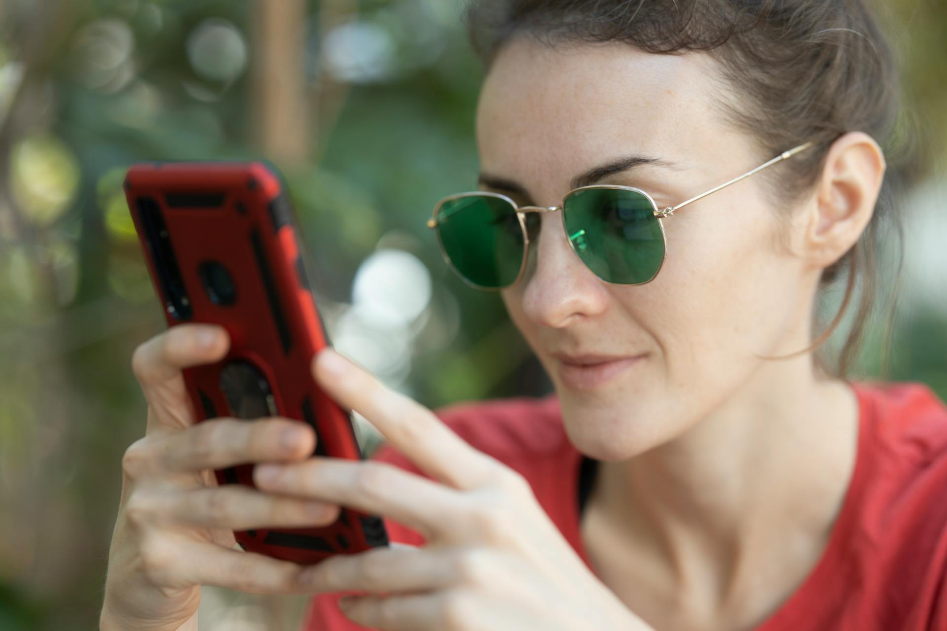 Une femme qui sourit en lisant un message texte | Source : Pexels