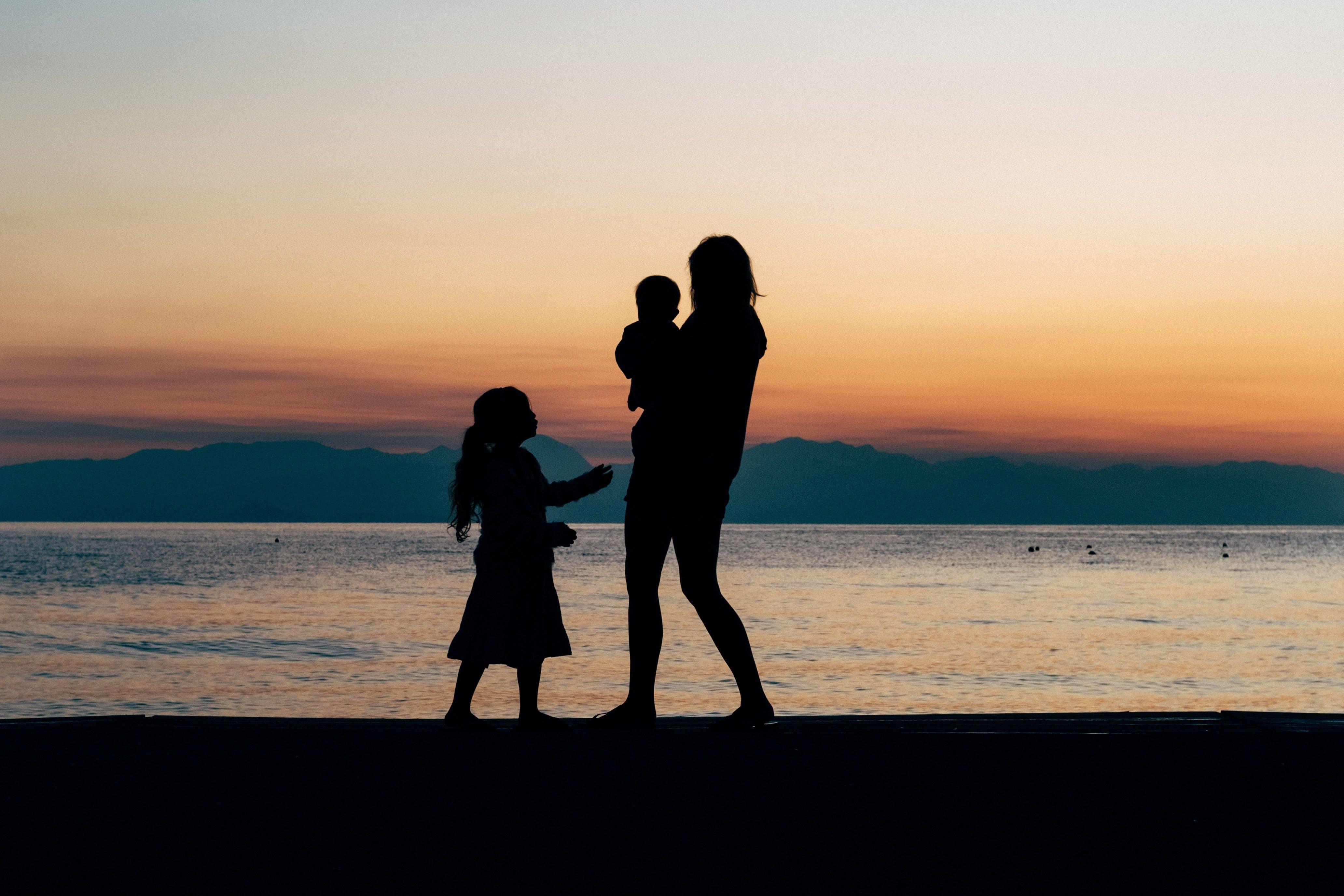 Une femme avec deux enfants à la plage | Source : Unsplash