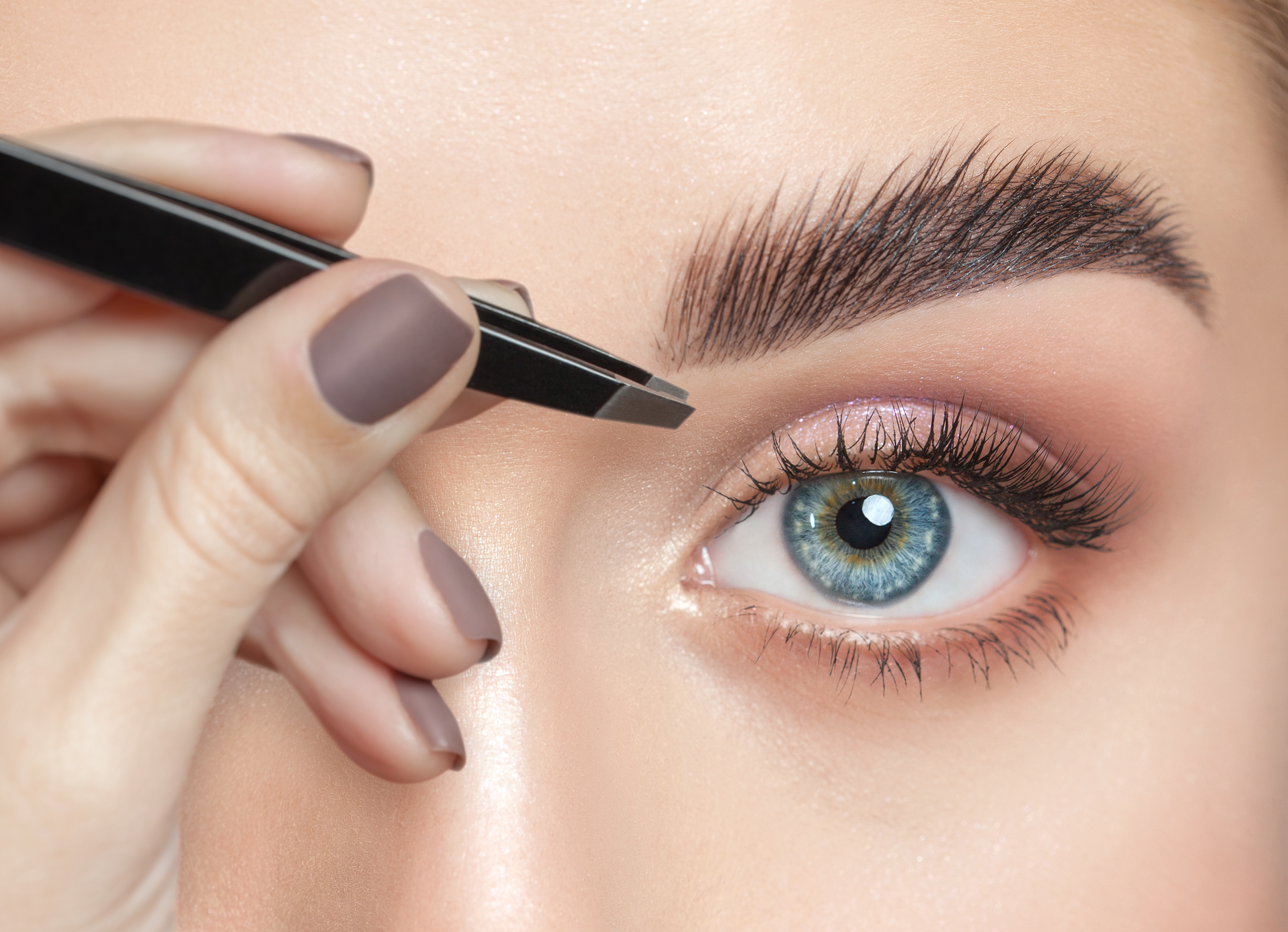 Femme s'épilant les sourcils | Source : Shutterstock