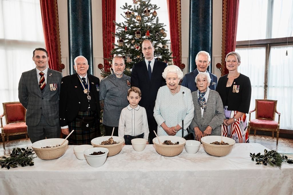 Des anciens combattants posent aux côtés du prince George, du prince William, du duc de Cambridge, de la reine Elizabeth II et du prince Charles, prince de Galles, dans la salle de musique du palais de Buckingham, dans le cadre du lancement de l'initiative Ensemble à Noël de la Légion royale britannique. | Photo : Getty Images