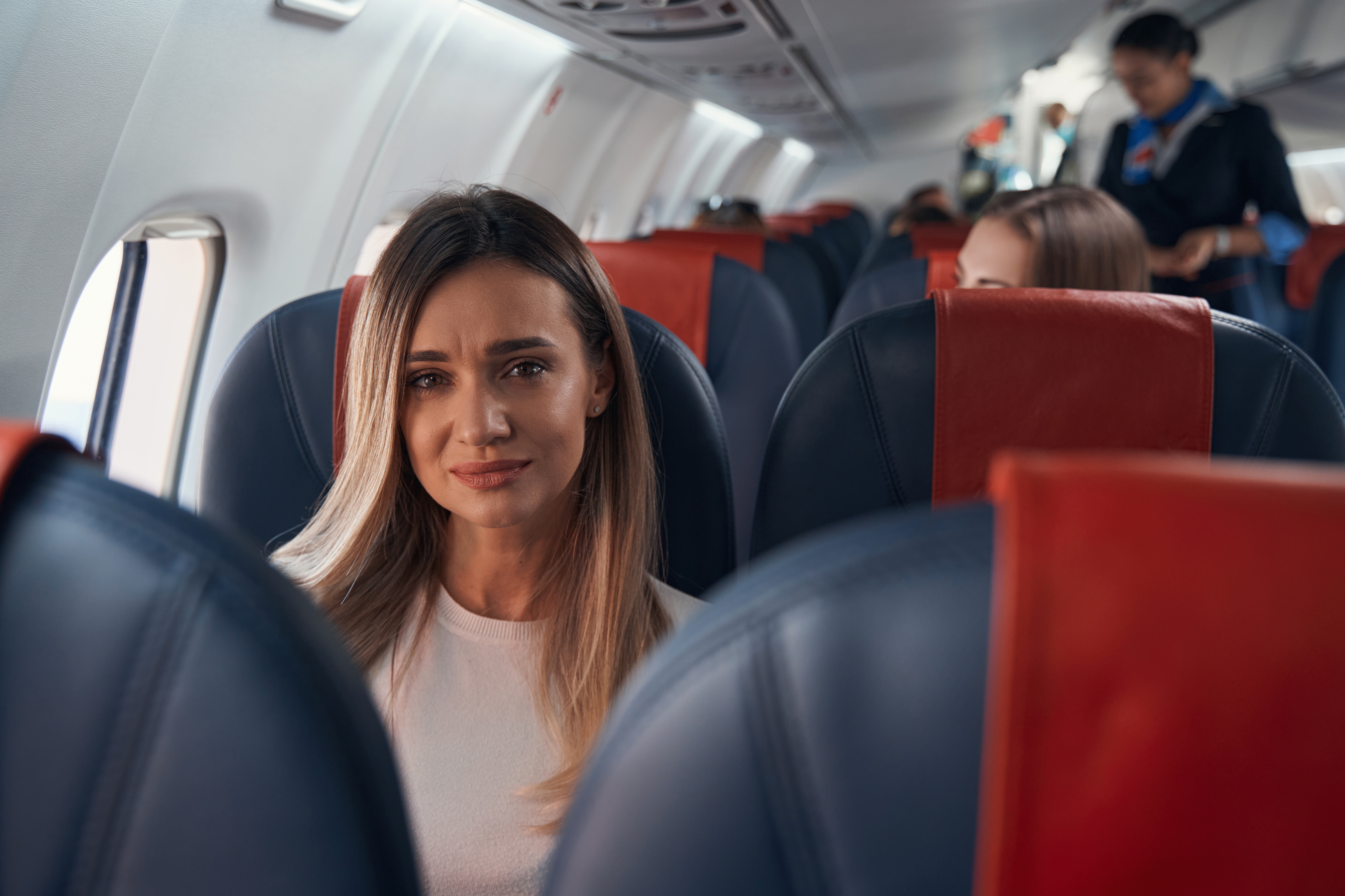 Mujer triste en un avión | Fuente: Shutterstock