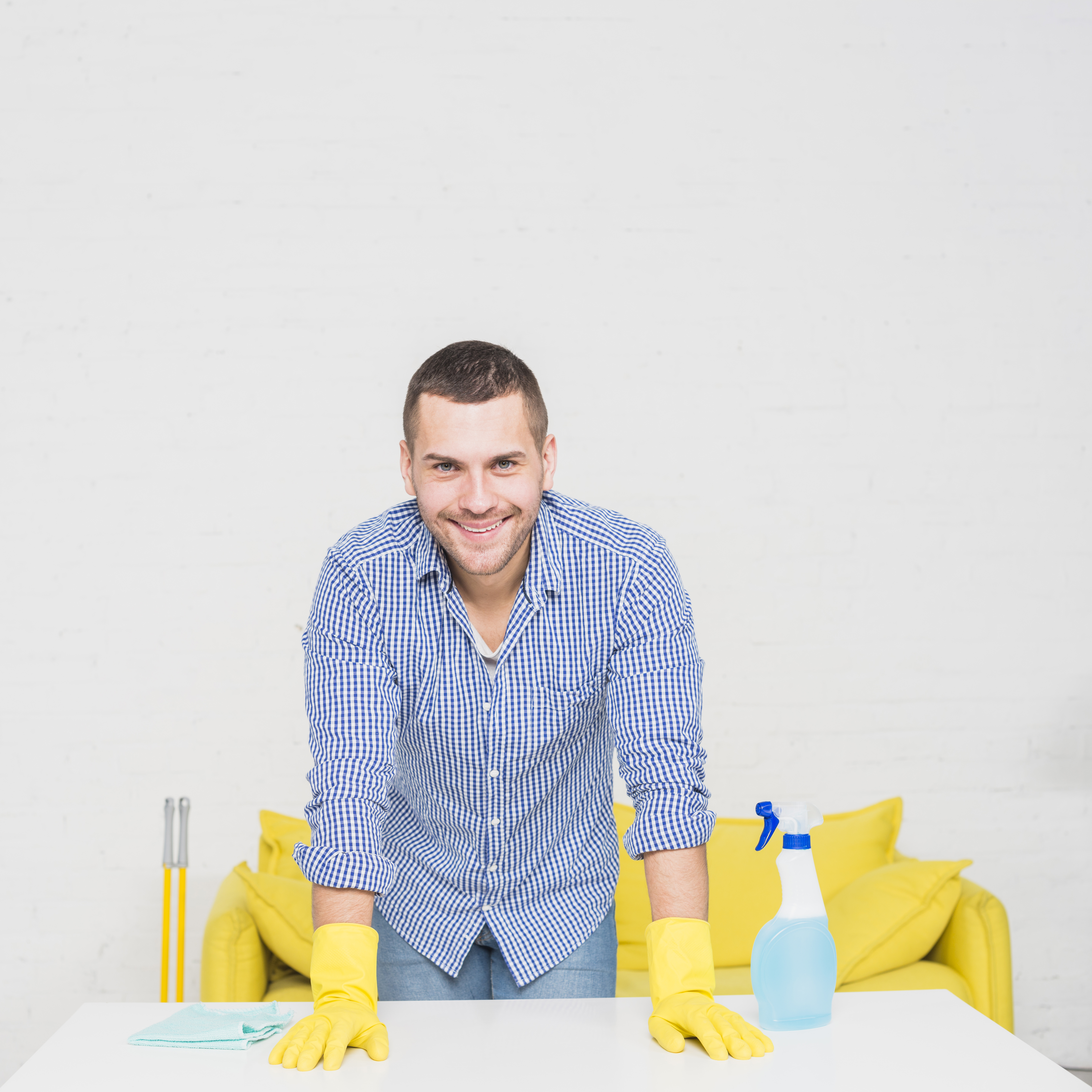 Homme souriant alors qu'il est entouré de matériel de nettoyage | Source : Freepik