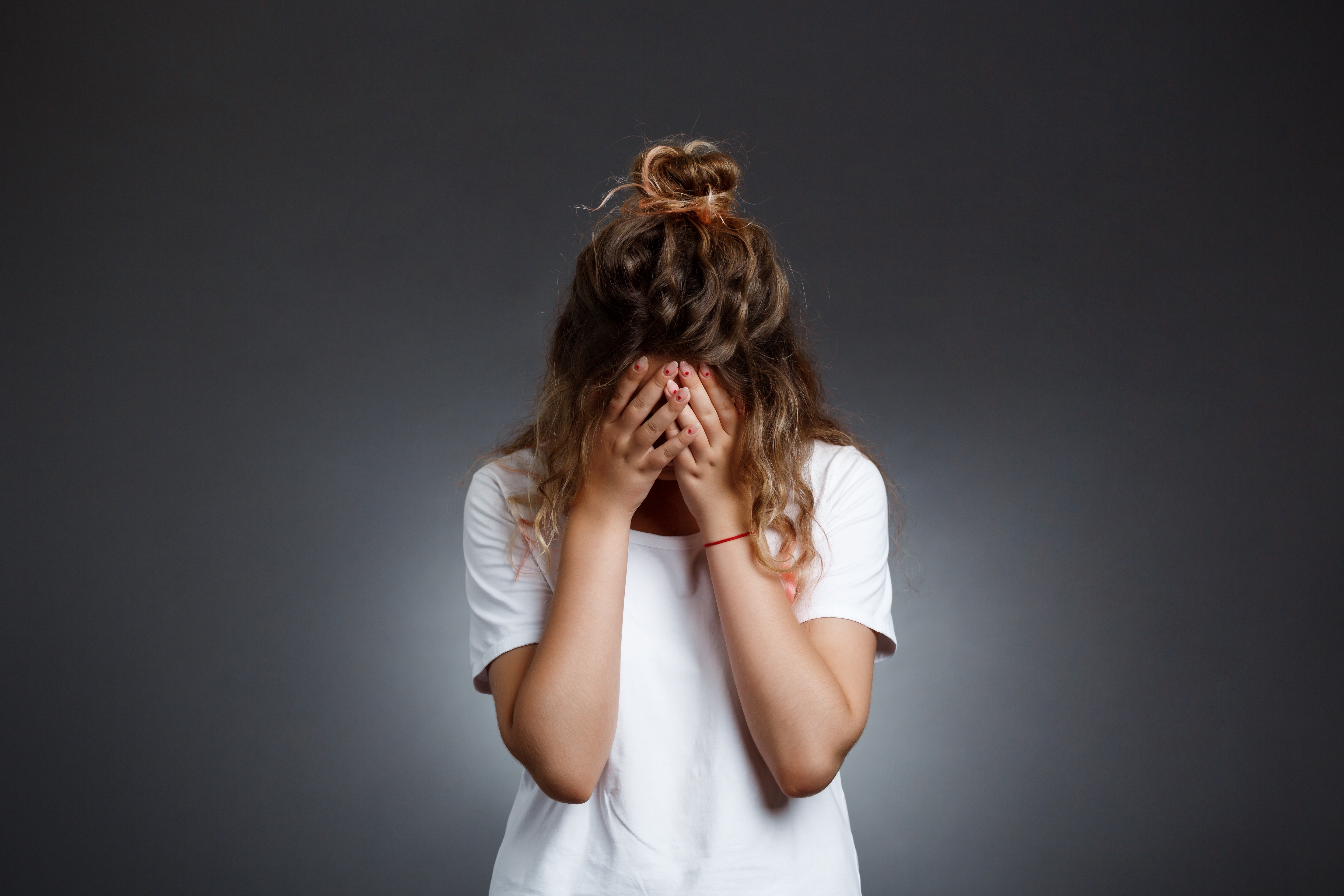 Jeune femme contrariée, la tête dans les mains | Source : Shutterstock