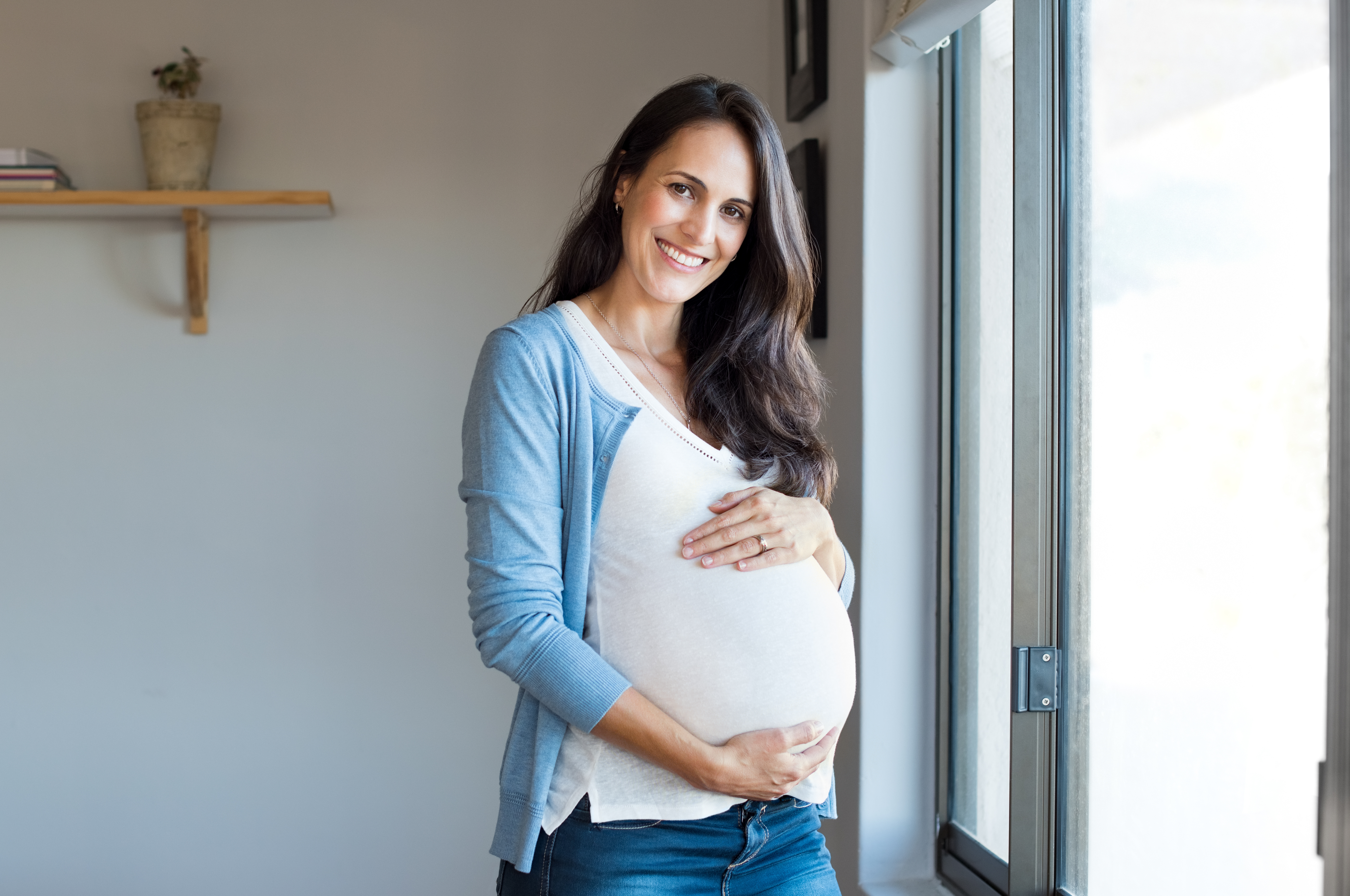 Femme enceinte heureuse tenant son baby bump | Source : Shutterstock