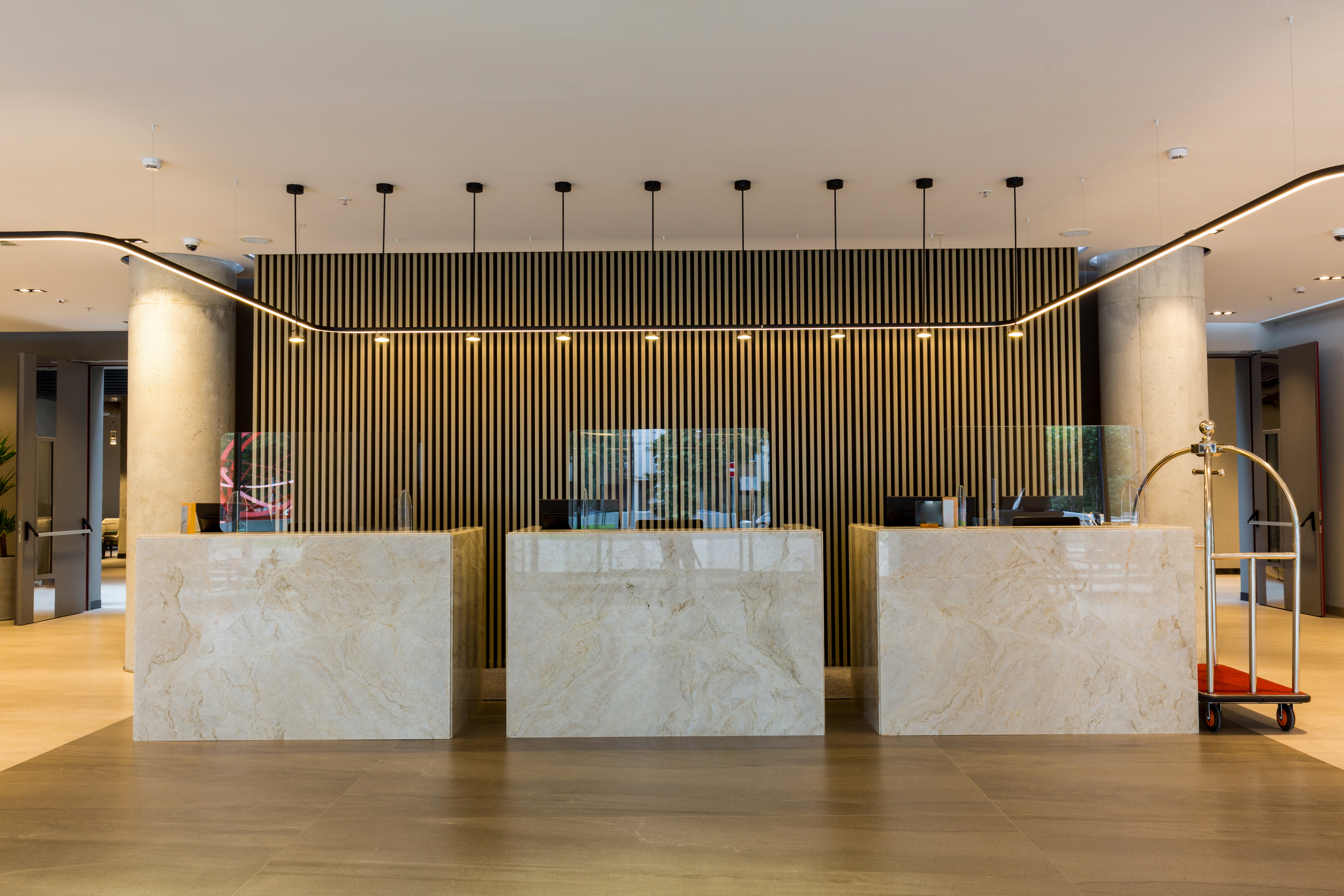 Interior de um lobby de hotel com balcões de recepção. | Fonte: Shutterstock