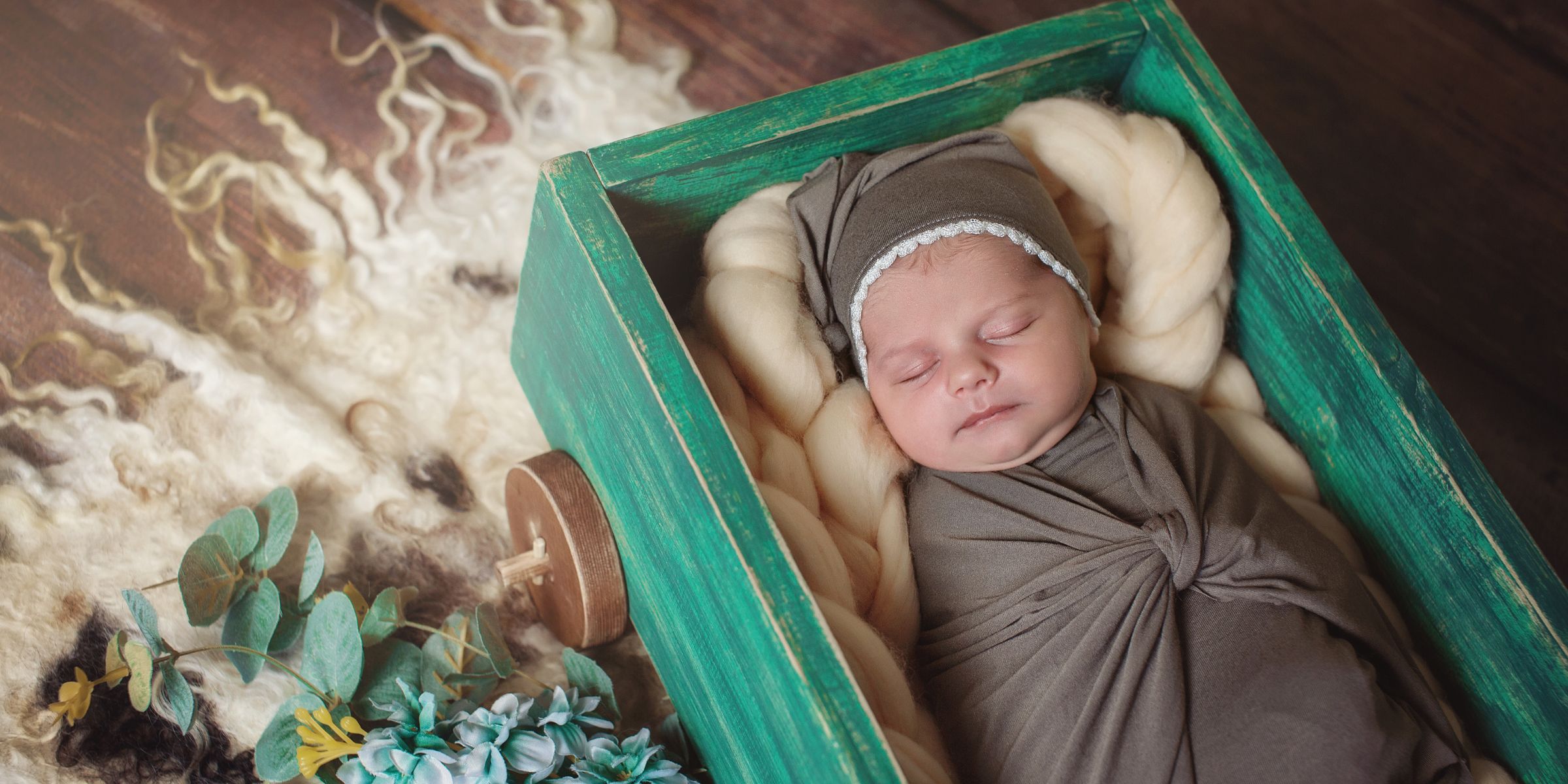 Un nouveau-né qui dort paisiblement, blotti dans un berceau en bois tout douillet | Source : Shutterstock