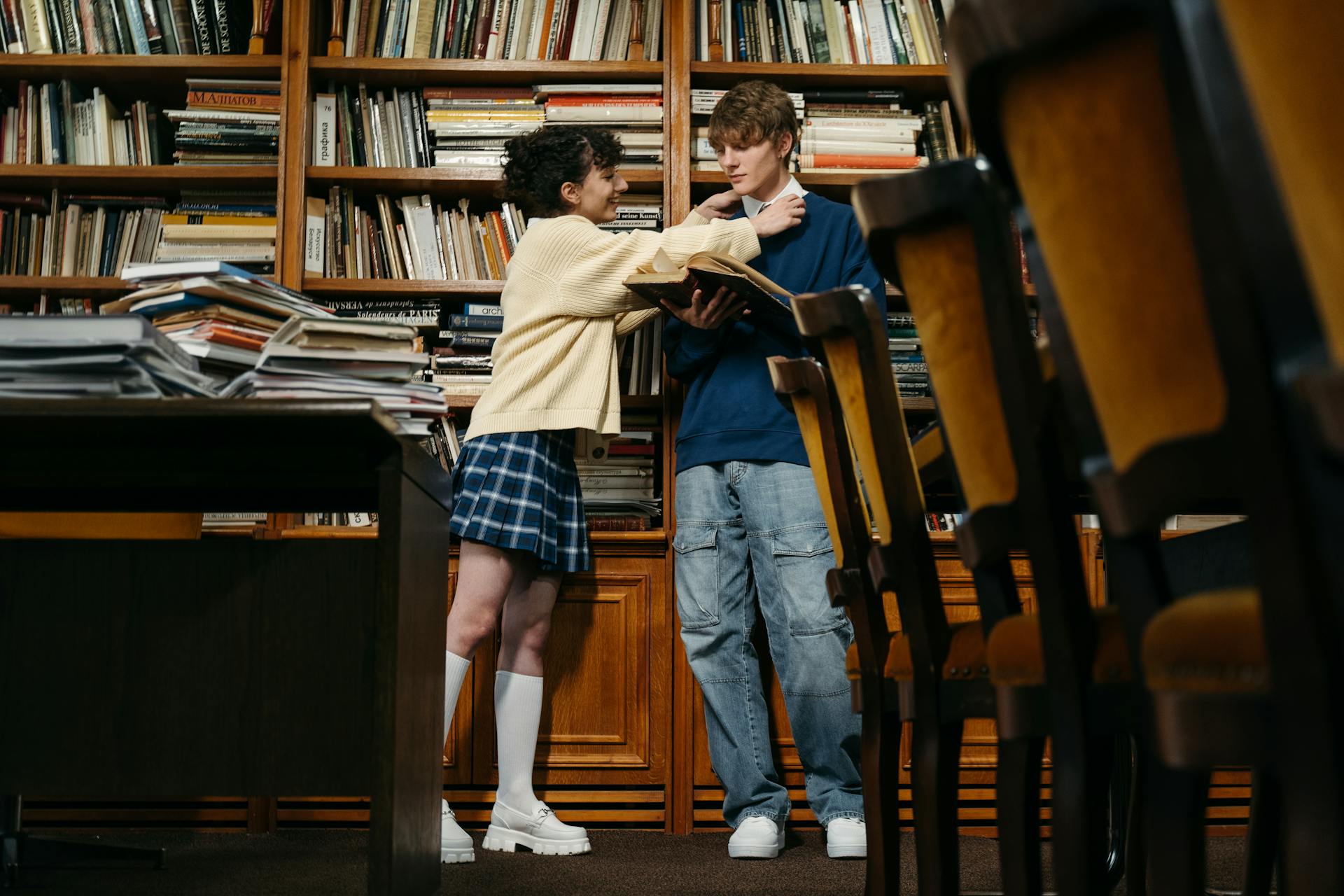 Un couple d'adolescents dans une bibliothèque | Source : Pexels
