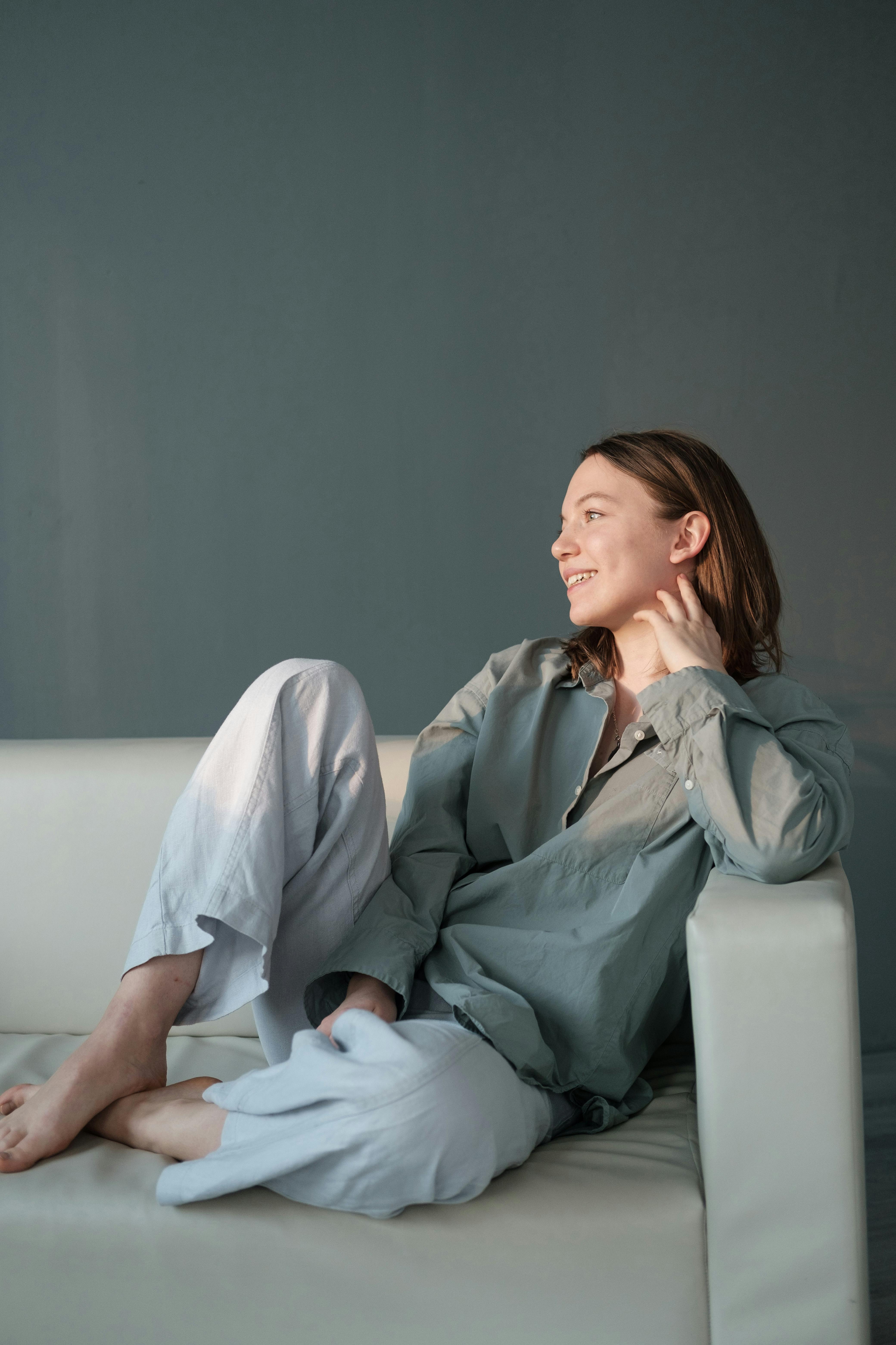 Une femme heureuse sur un canapé | Source : Pexels