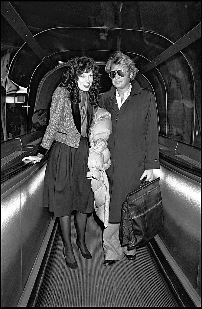 Johnny Hallyday et sa compagne Babeth Etienne à l'aéroport. | Photo : Getty Images