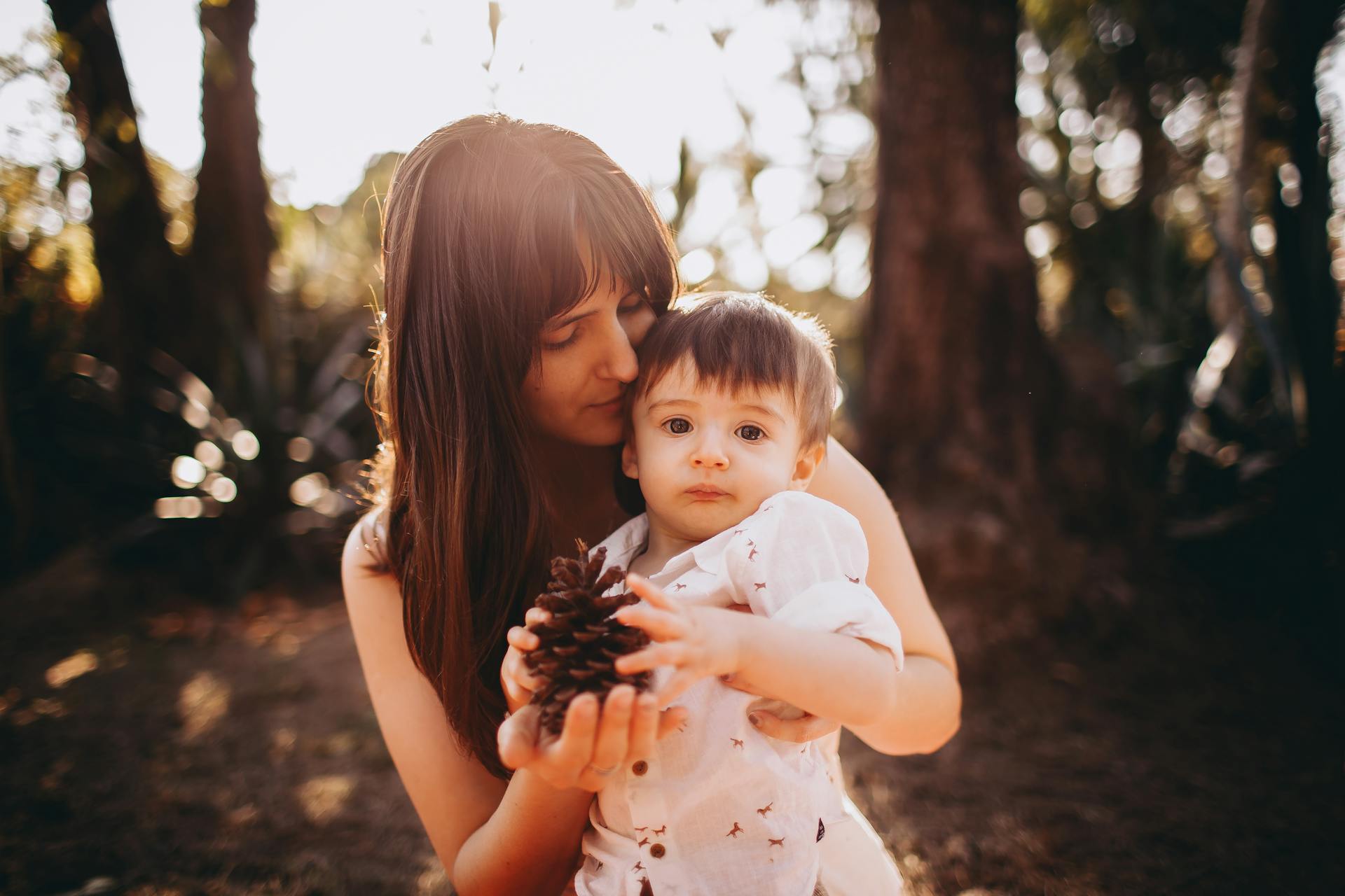 Une mère et son fils tenant une pomme de pin | Source : Pexels